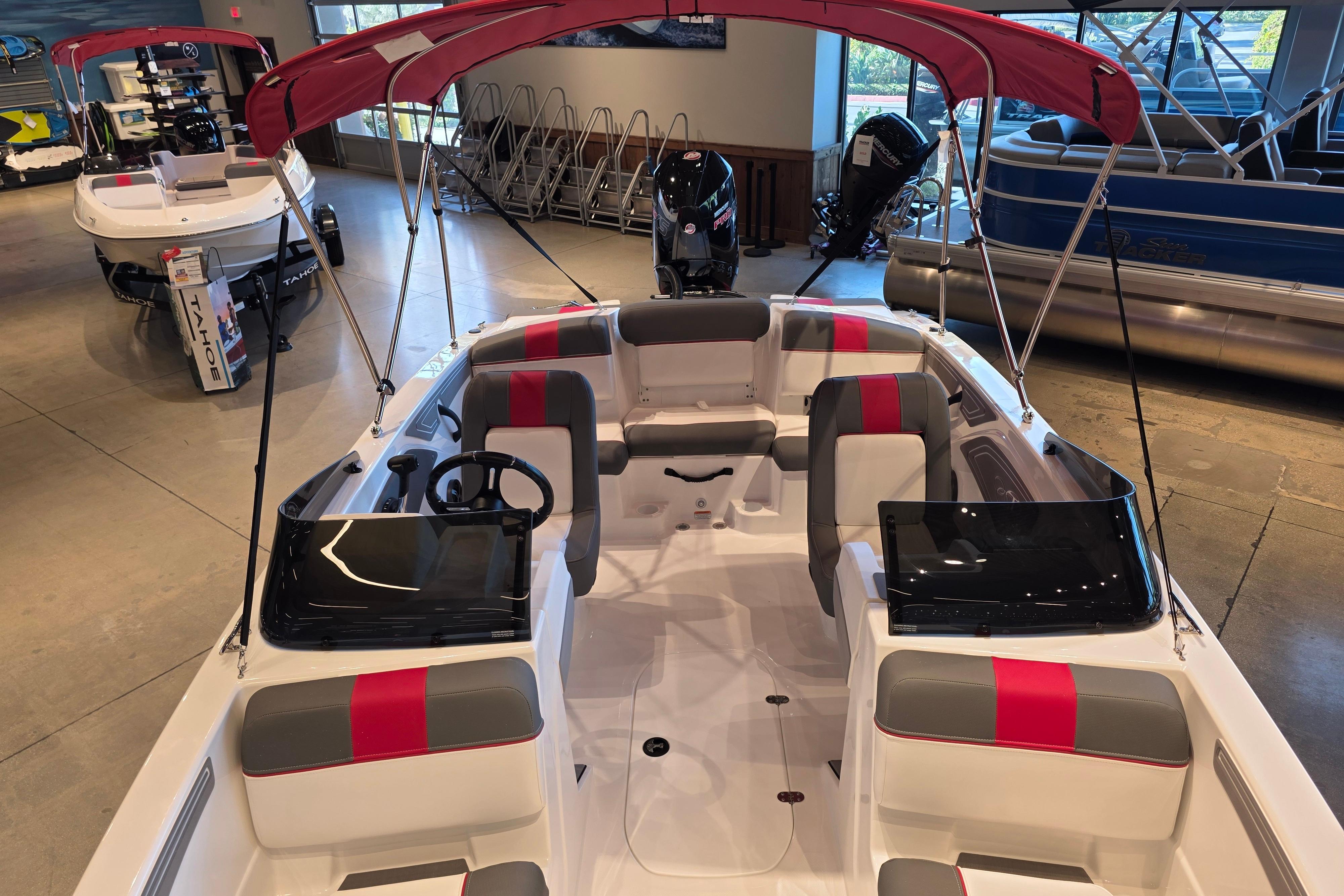 2026 Tahoe T21 boat with red canopy and modern interior in showroom.