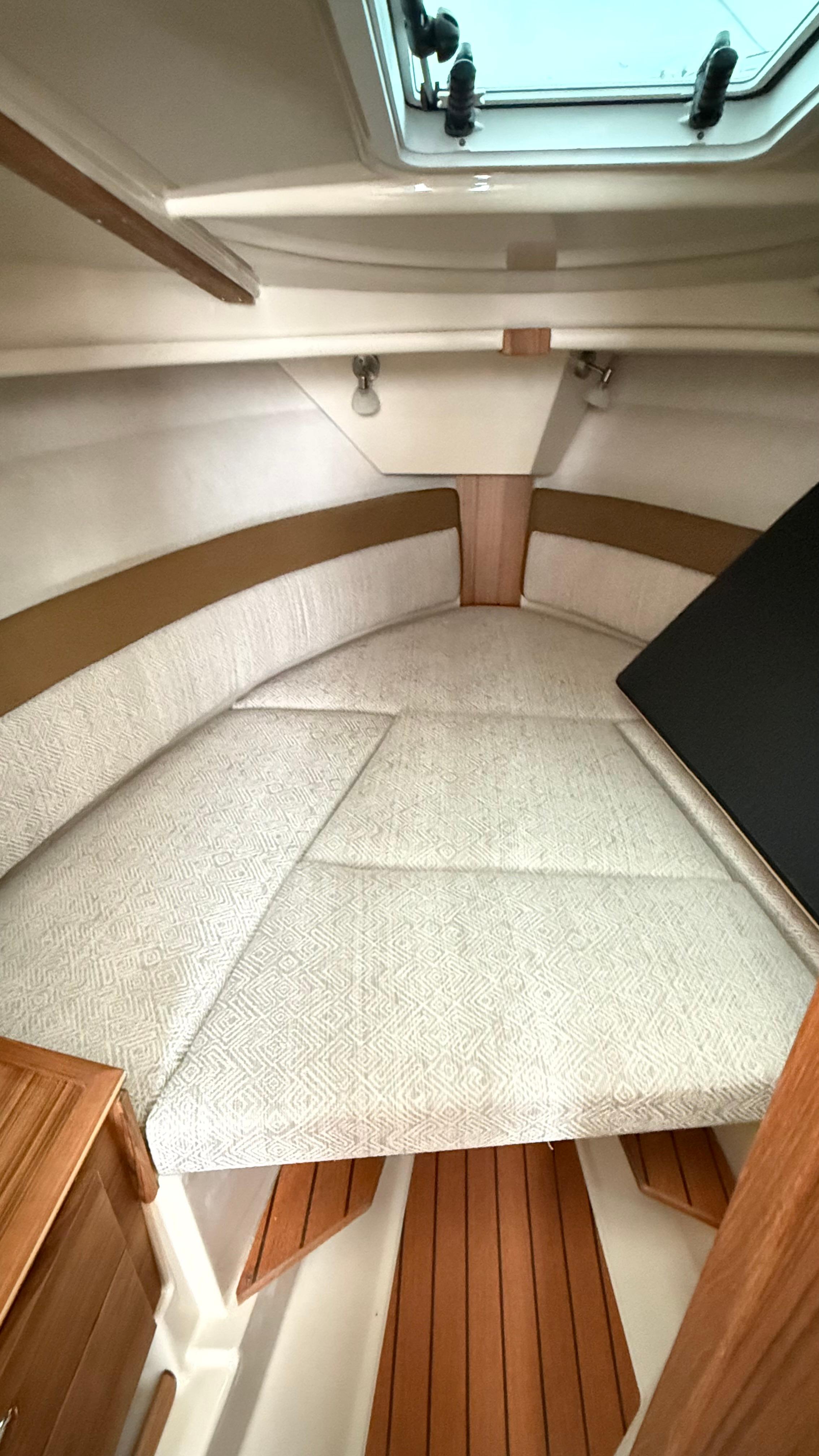 2026 Ranger Tugs R-27 cabin interior with cushioned seating and wooden accents.