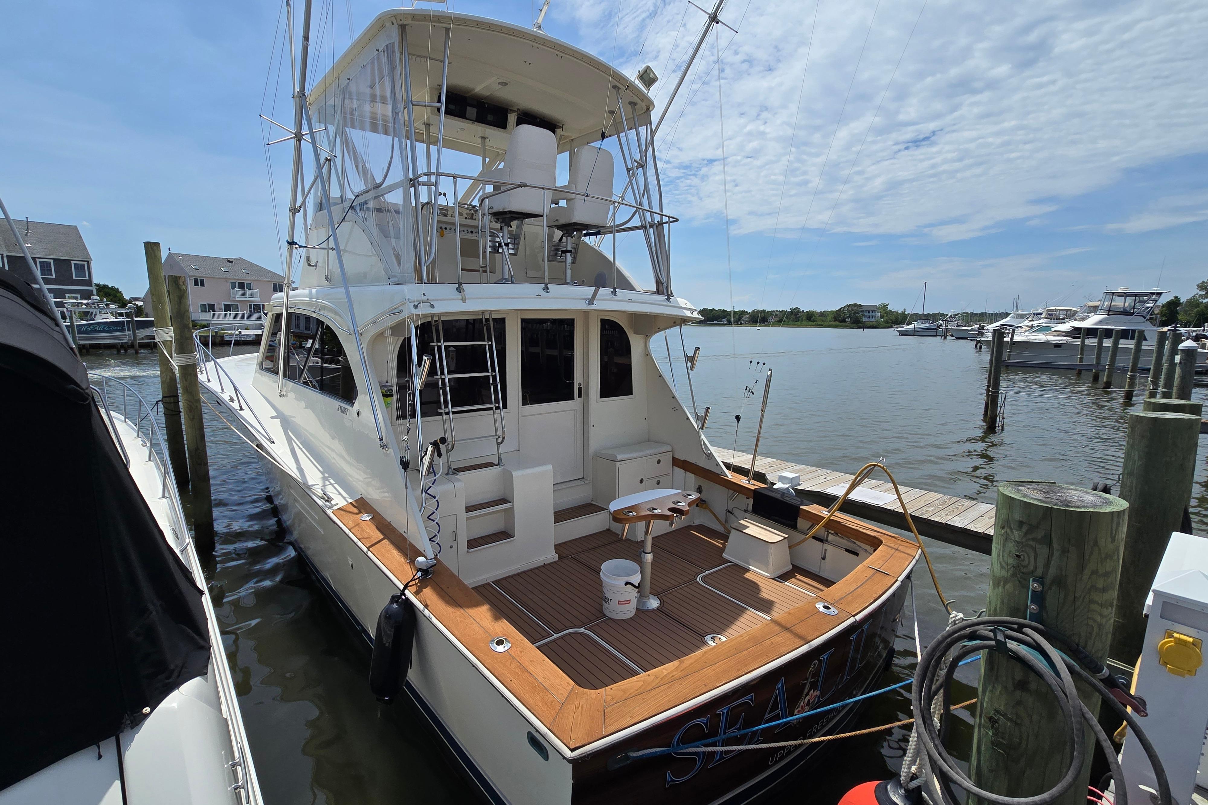 1988 Post 46 Convertible yacht docked at marina under partly cloudy sky.