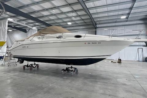 1998 Sea Ray 270 Sundancer boat in a spacious indoor storage facility.