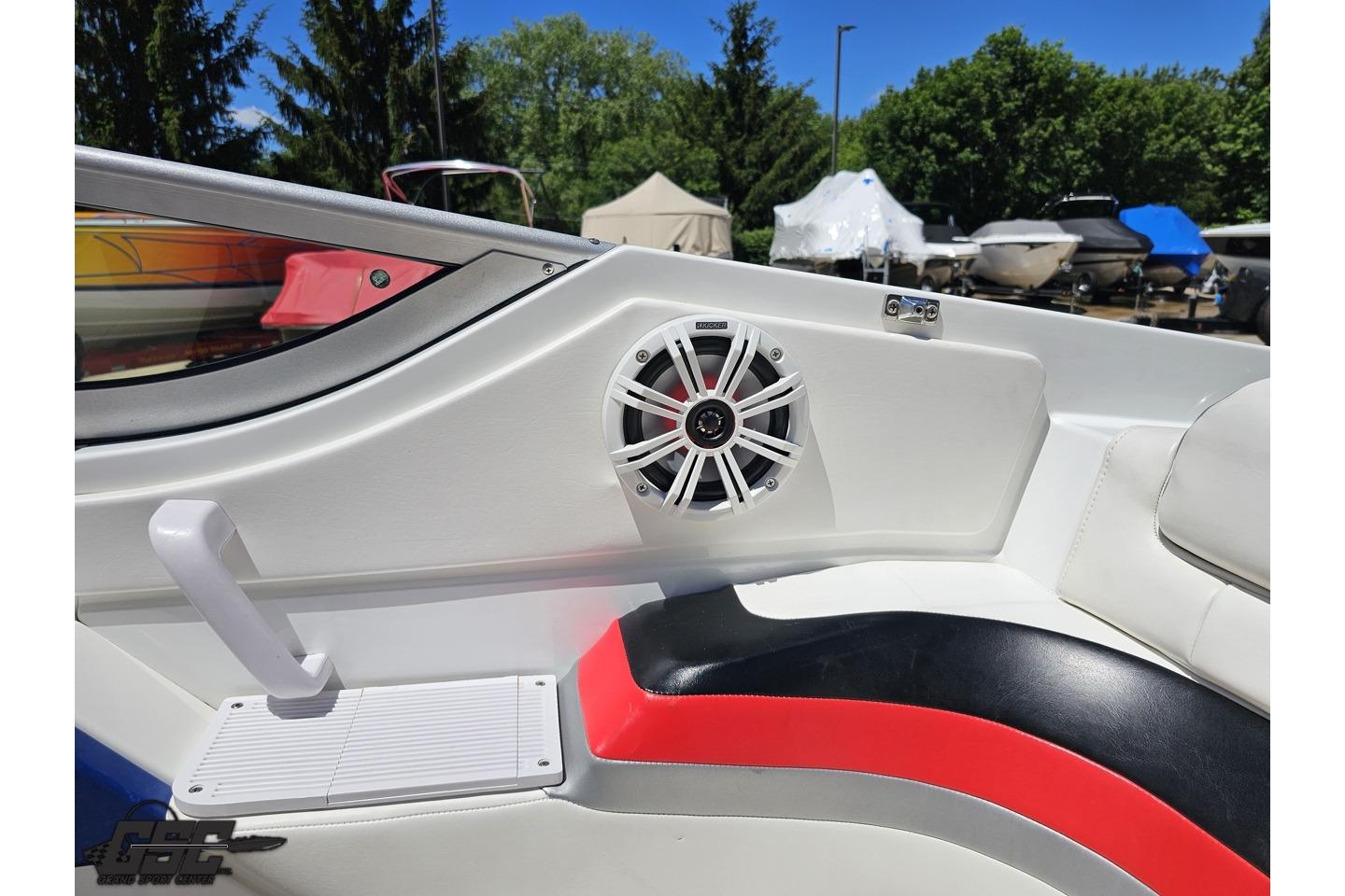 2005 Formula 271 FASTech boat interior with speaker and seating, surrounded by trees and other boats.