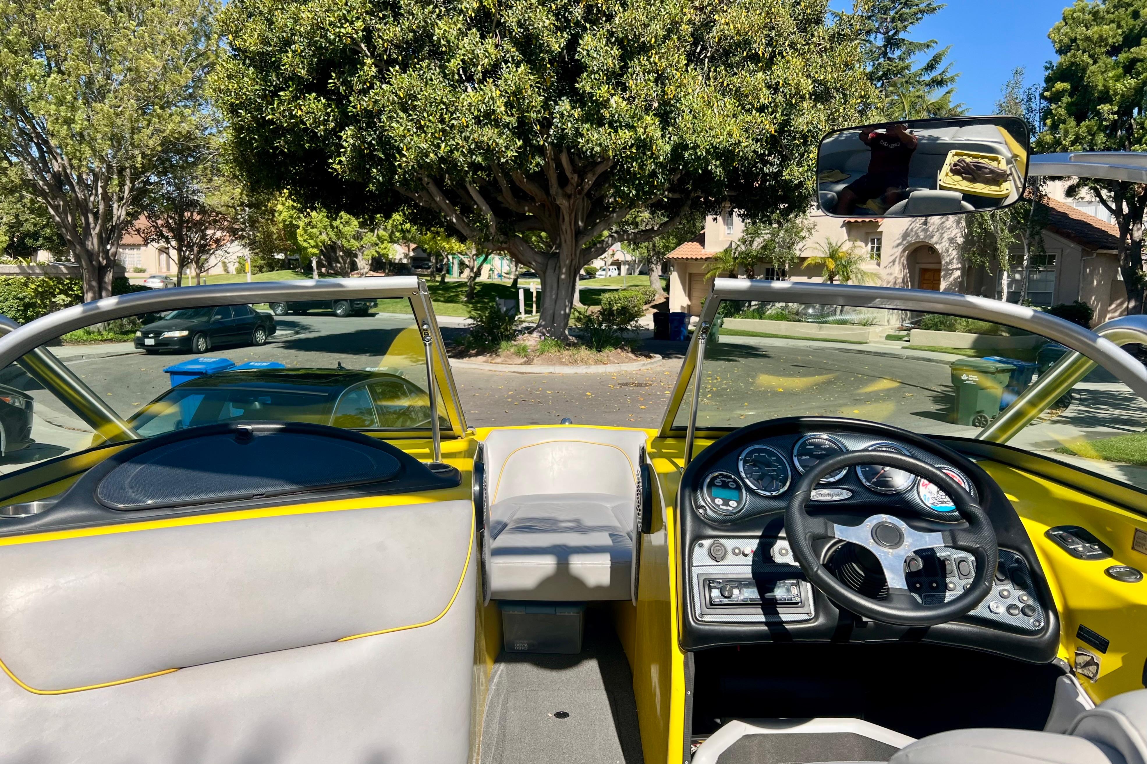 Interior view of a 2006 Sanger V230 boat with steering wheel and dashboard.