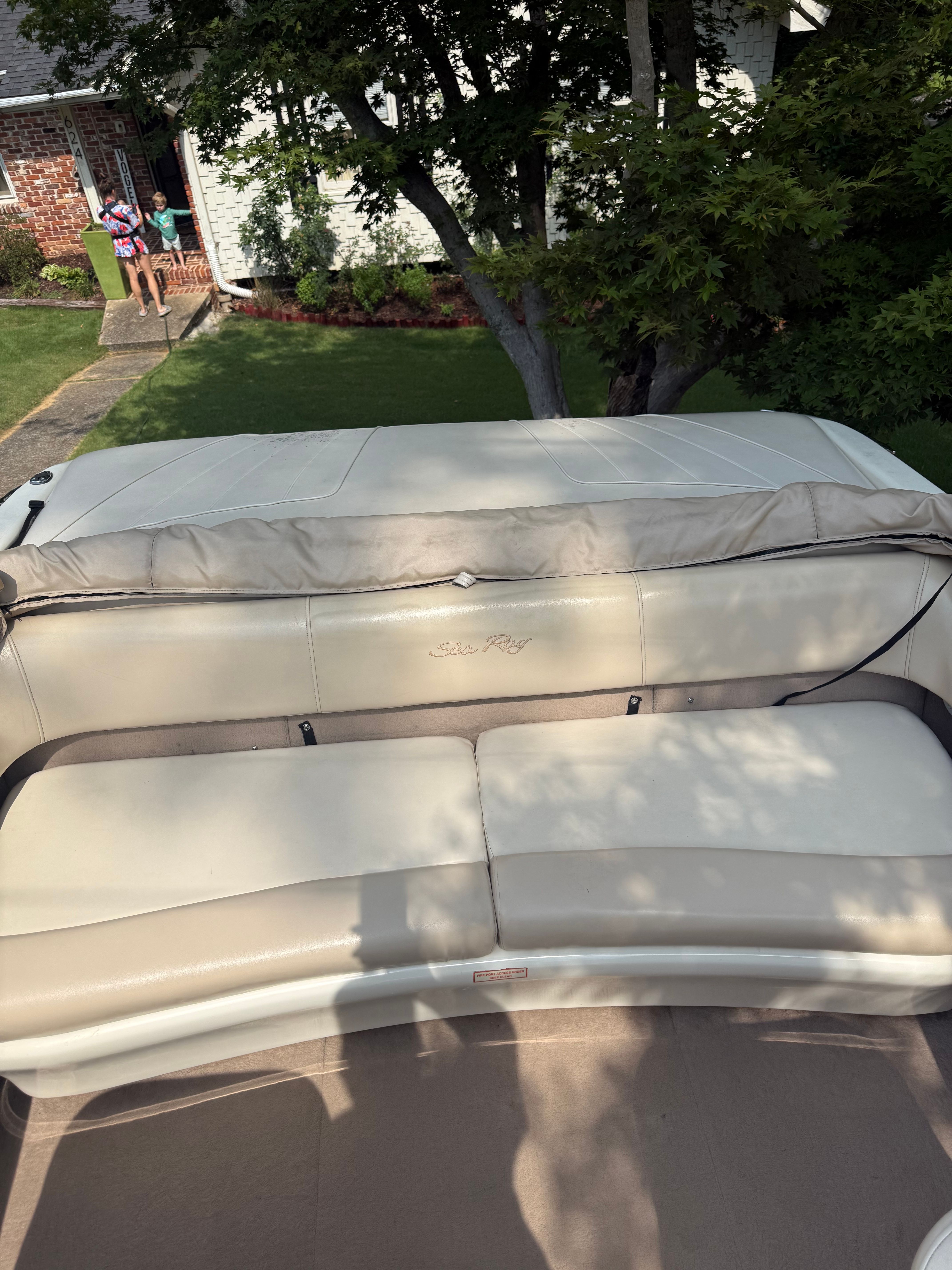 Rear view of a 1999 Sea Ray 210 Bow Rider Signature with beige upholstered seating.