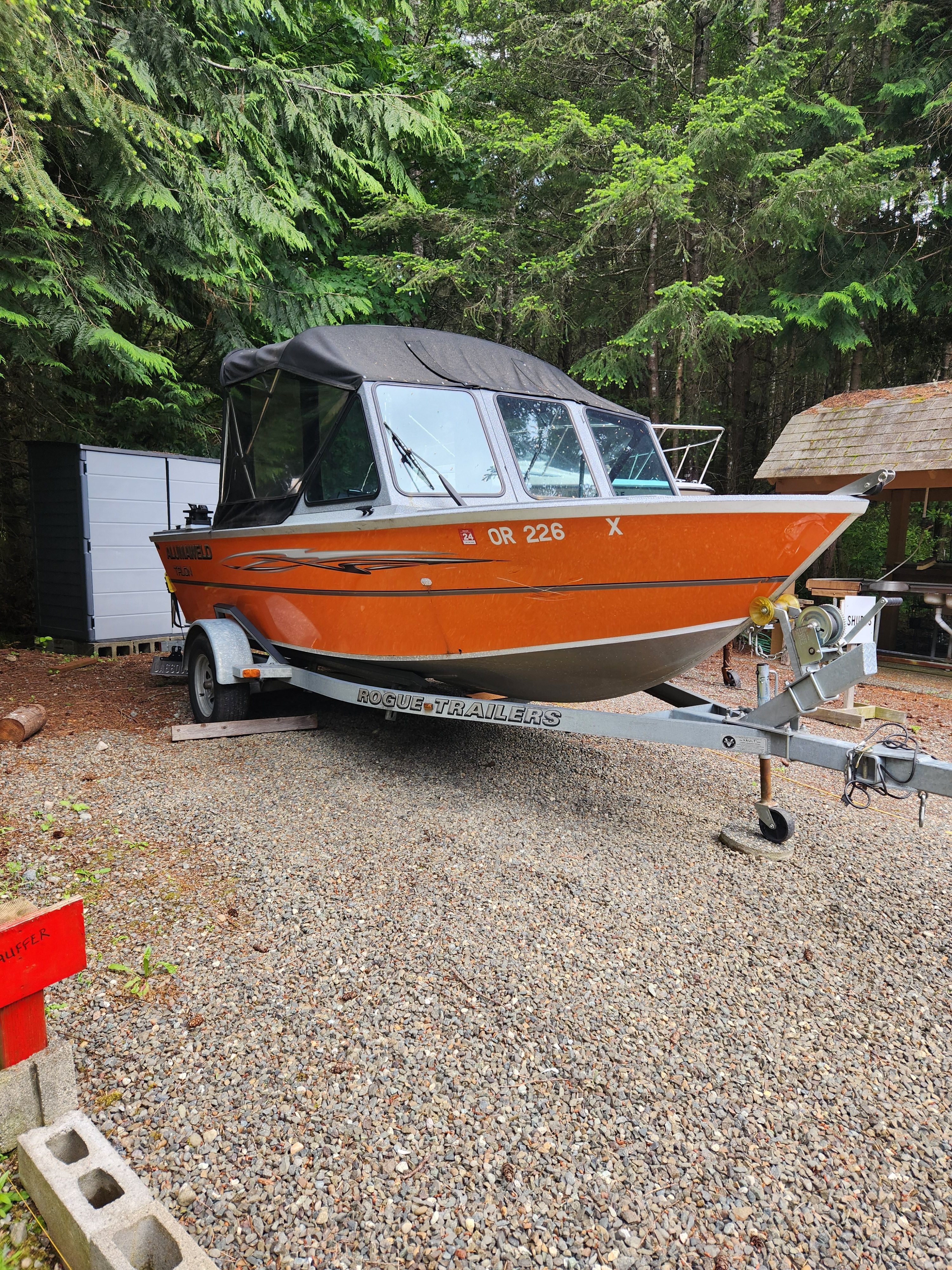 2020 Alumaweld Talon 18 boat on trailer parked in forest.