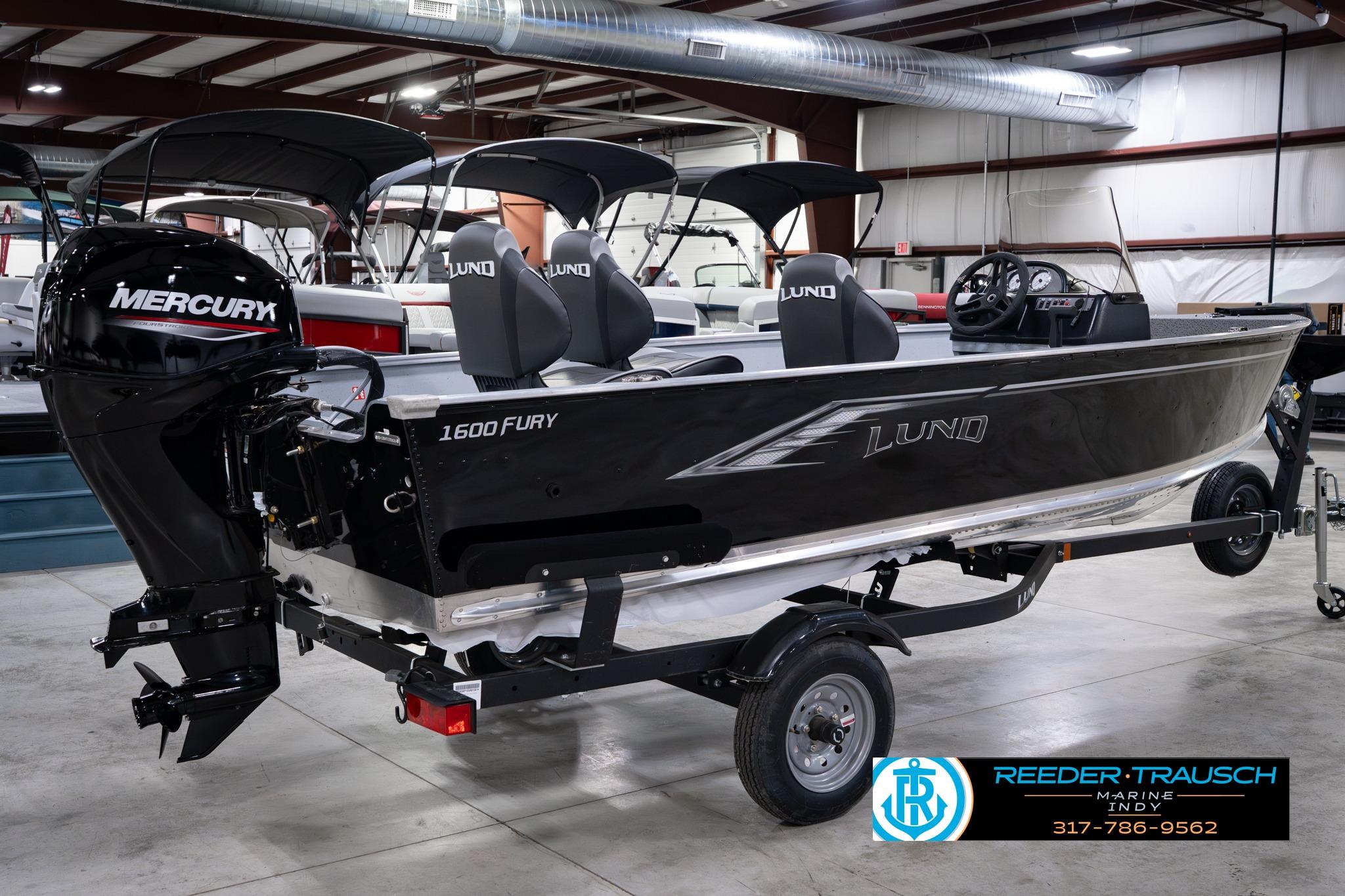 2026 Lund 1600 Fury SS boat with Mercury engine in showroom, displayed on trailer.