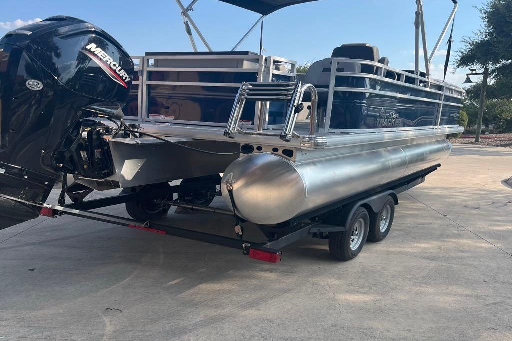 2026 Sun Tracker SportFish 20 DLX pontoon boat on trailer with Mercury outboard motor.