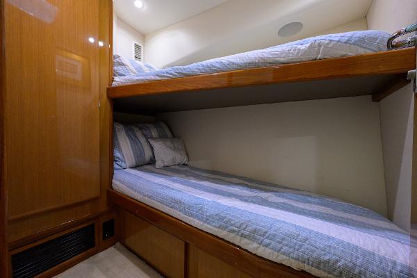 Bunk beds in 2000 Viking 50 Convertible yacht cabin, featuring wood paneling and cozy bedding.