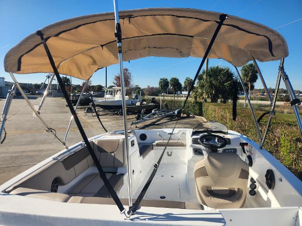 2025 Tahoe 1950 boat with canopy, beige interior, parked outdoors.