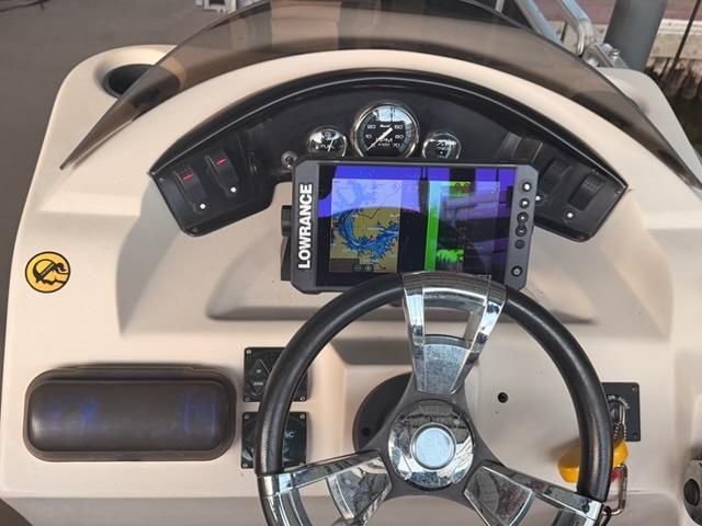 The image shows a boat's helm with a Lowrance navigation system.