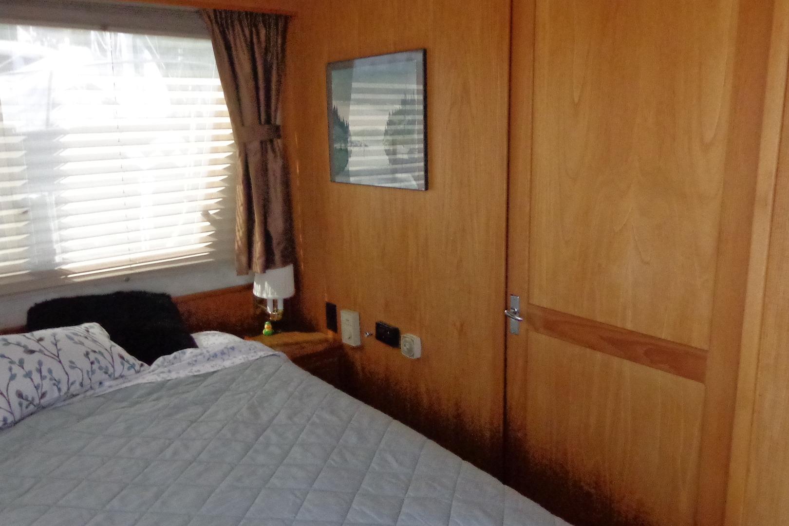 Interior of 1992 Cruise-A-Home Corsair 4200 with cozy bedroom and wooden paneling.