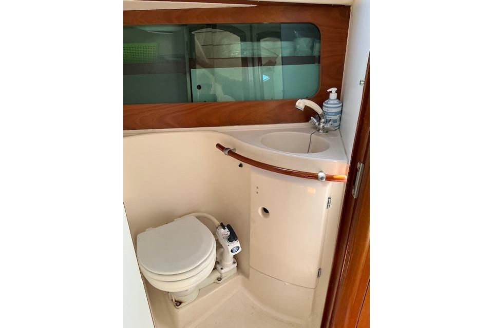 Beneteau Oceanis 321 yacht bathroom with toilet and sink, featuring wood accents, 2000 model.
