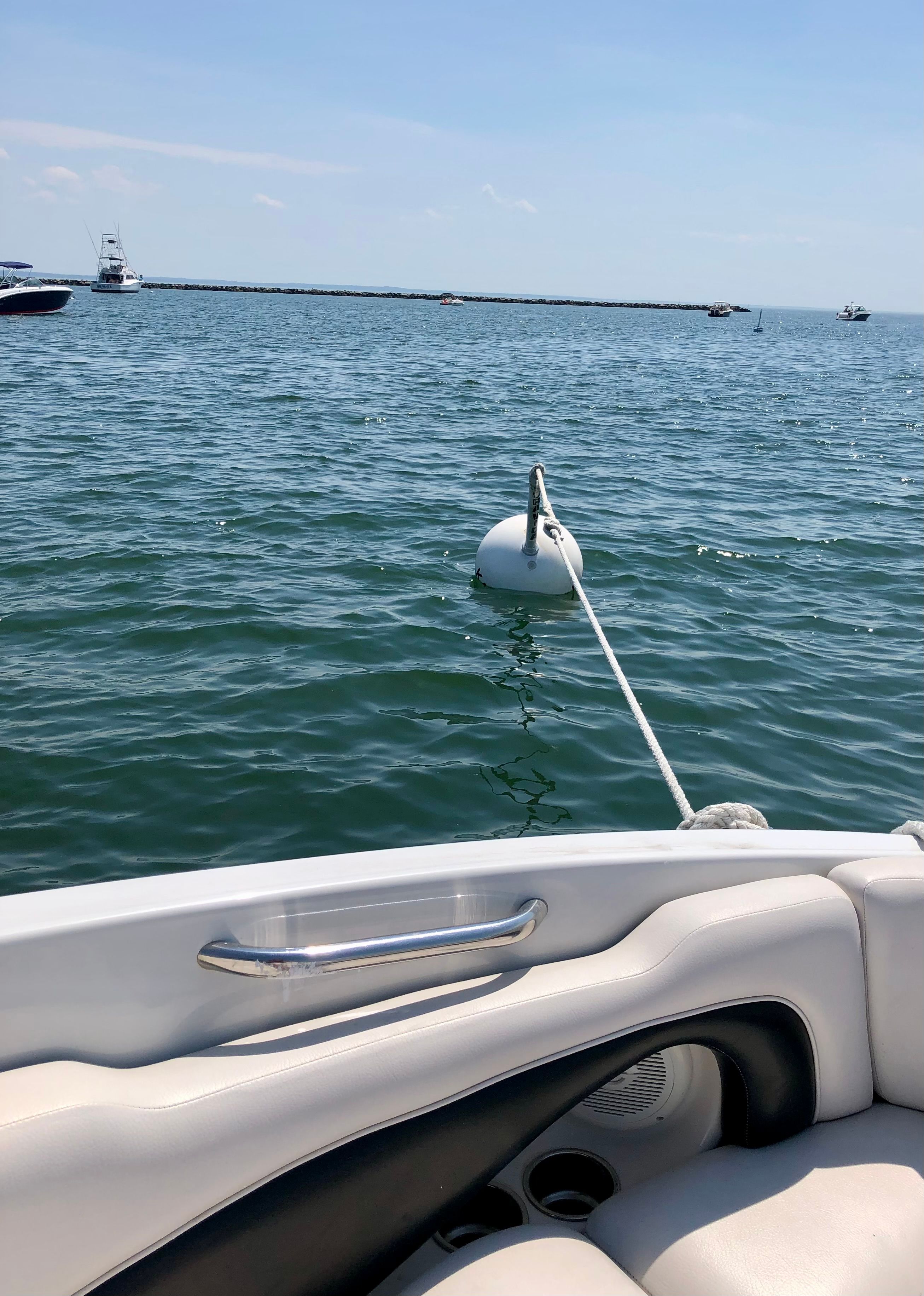 A boat on the water with a buoy in the foreground.