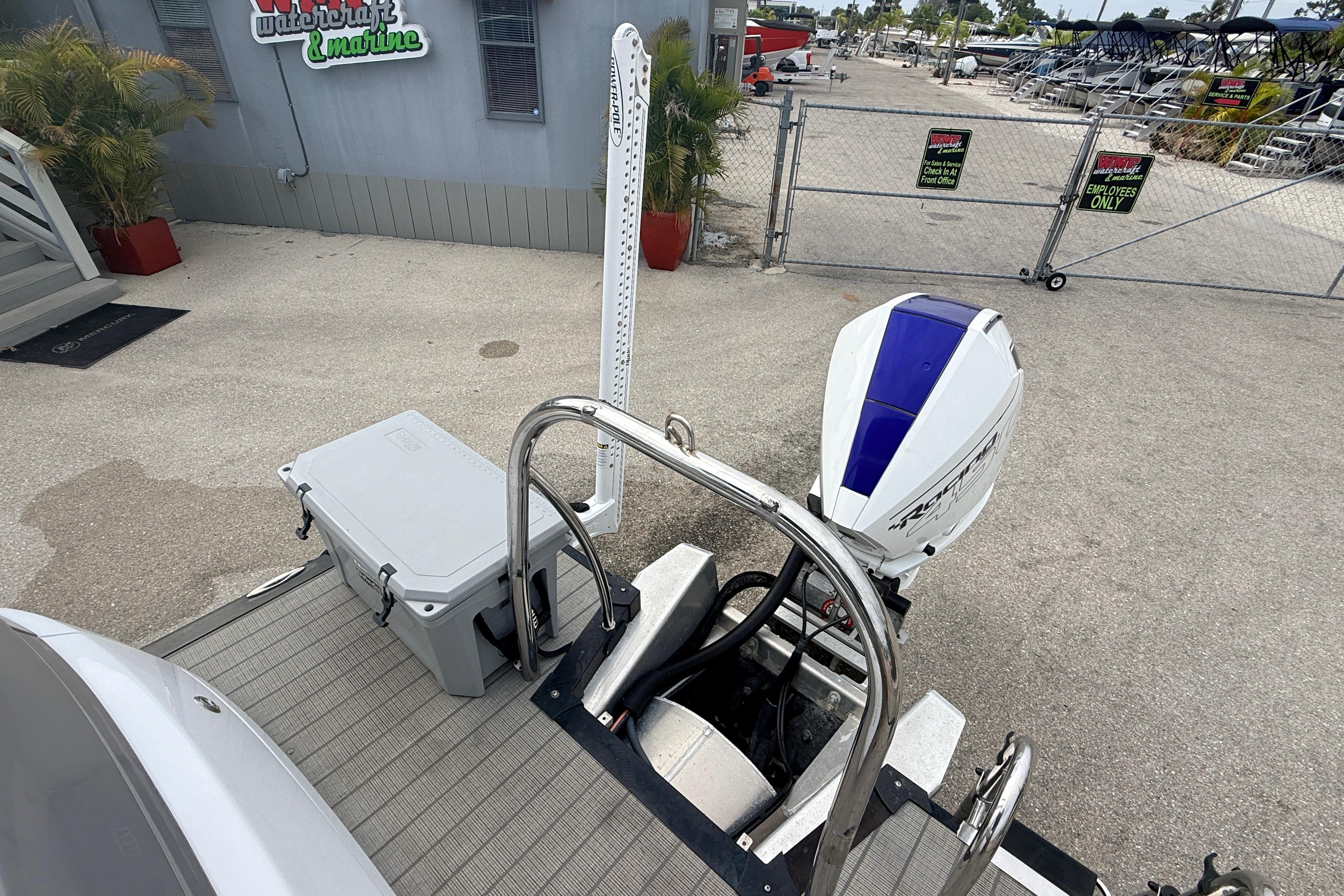 2023 Avalon Excalibur 2585 boat with powerful 450R engine, docked at a marine facility.