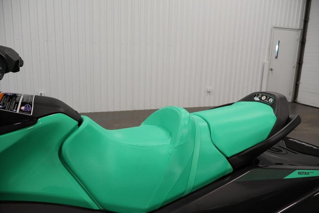 2026 Sea-Doo GTI SE 130 jet ski with vibrant green seat in a showroom.
