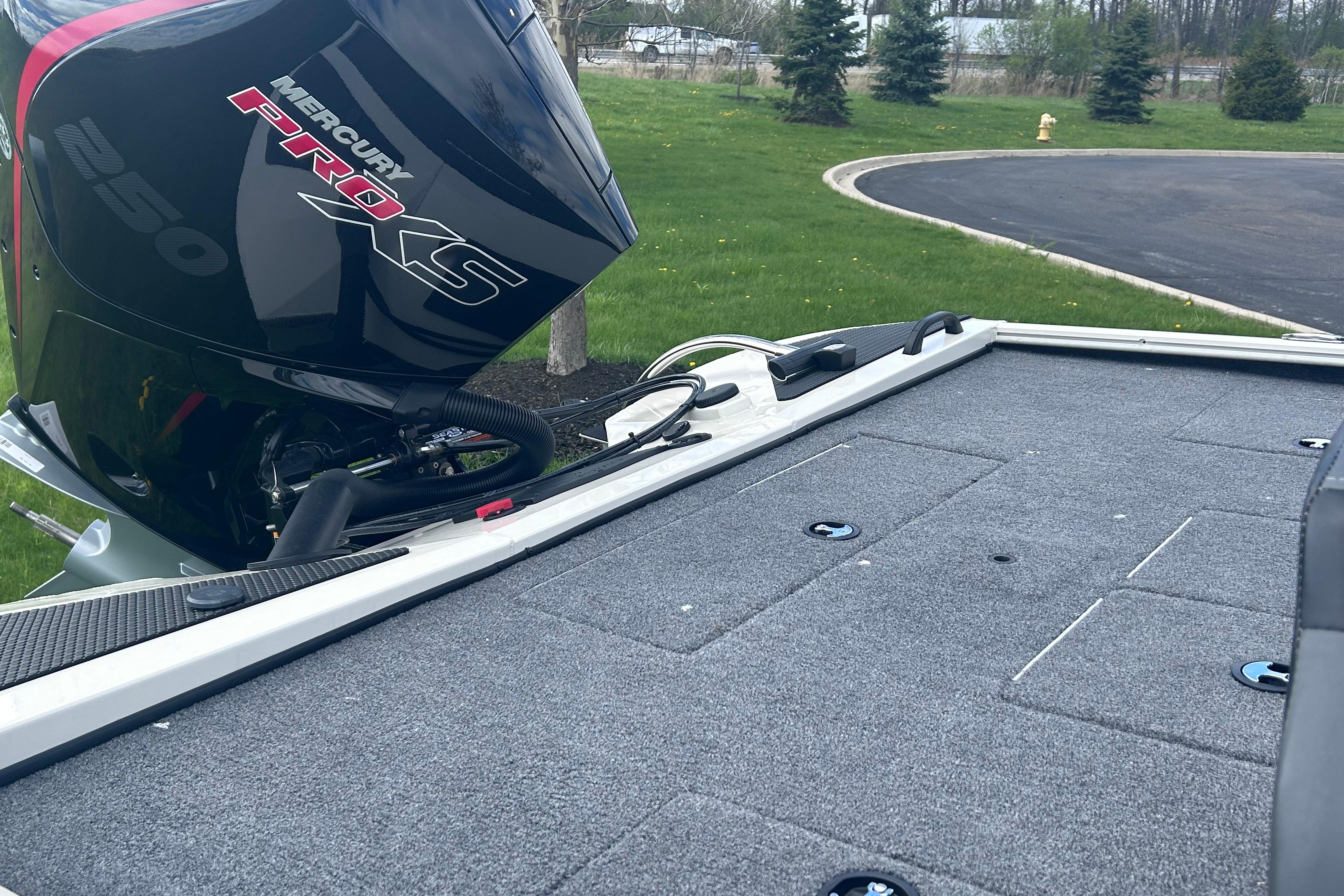 2025 Tracker Savage 215 boat with Mercury Pro XS 250 engine on grassy area.