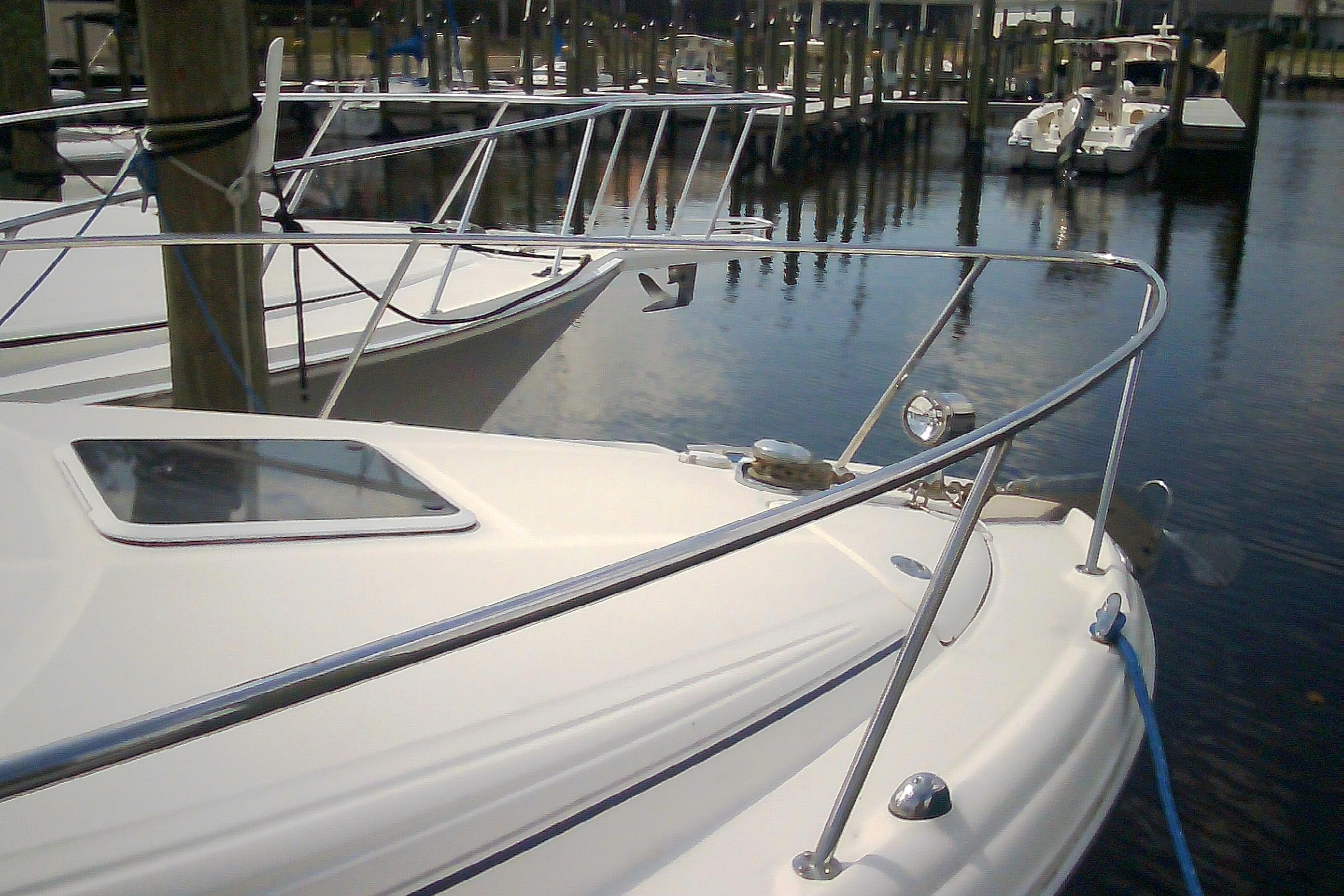 2005 Sea Ray 300 Sundancer docked at marina, showcasing sleek design and polished railings.