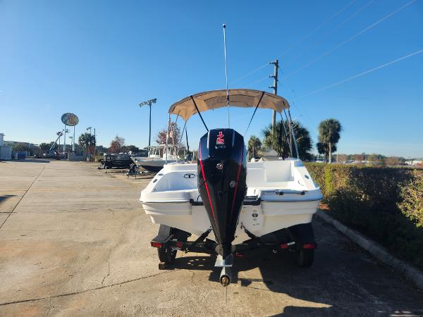 2025 Tahoe 1950 boat with canopy and outboard motor in a sunny parking lot.
