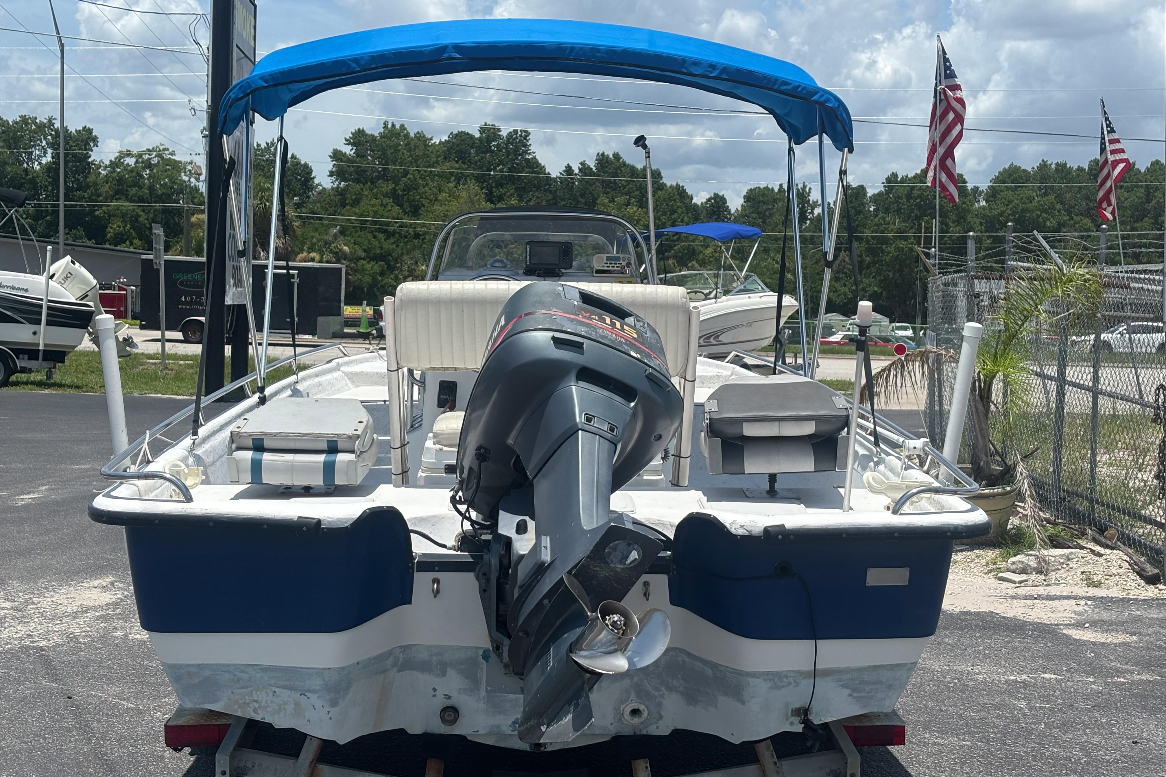 2000 VIP 1880 BAY STEALTH boat with blue canopy and outboard motor.