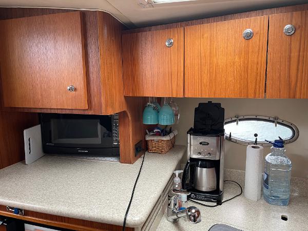 2003 Tiara Yachts 3500 Open galley with wooden cabinets, microwave, and coffee maker.