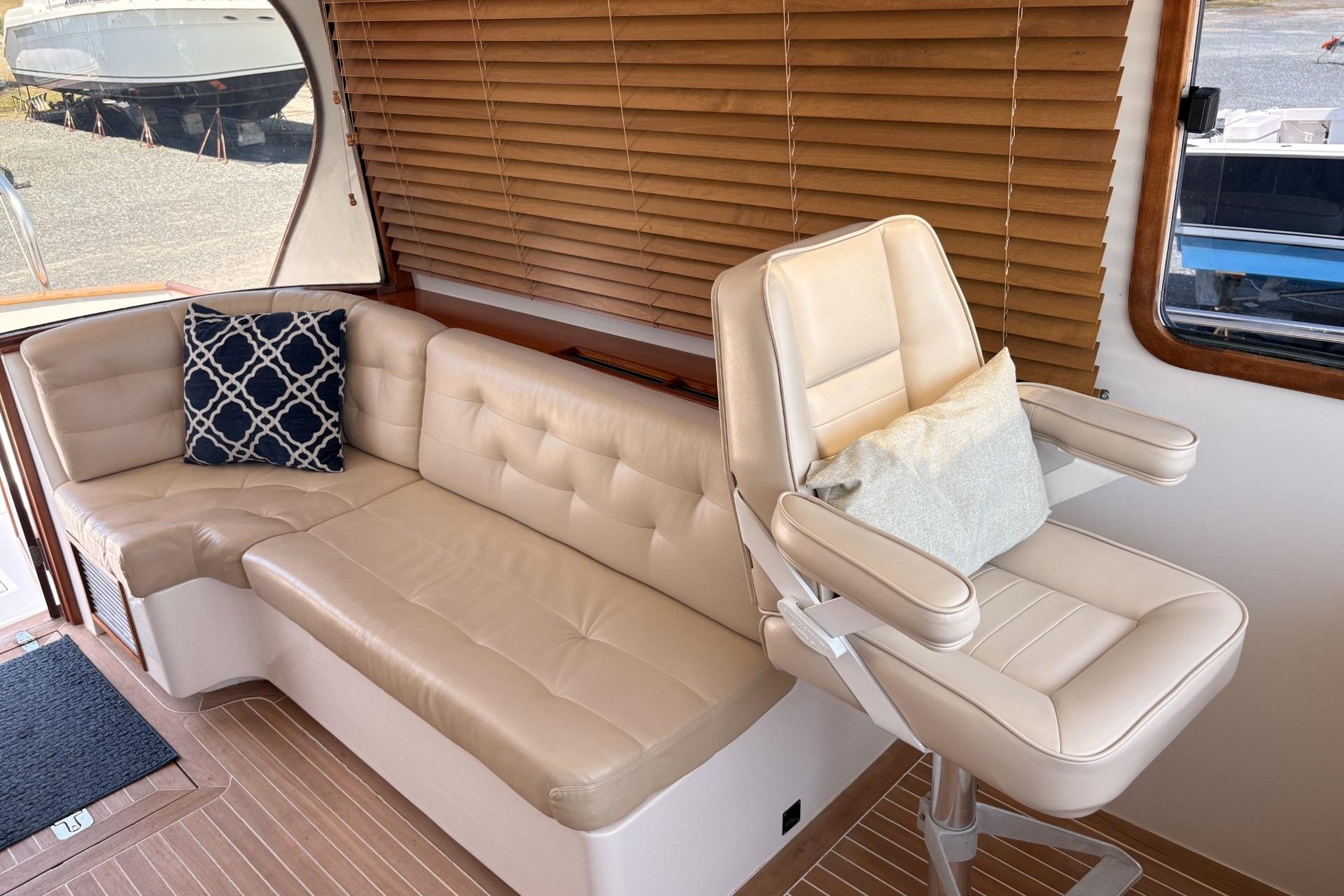 Luxurious boat interior with beige leather seating and decorative pillows.