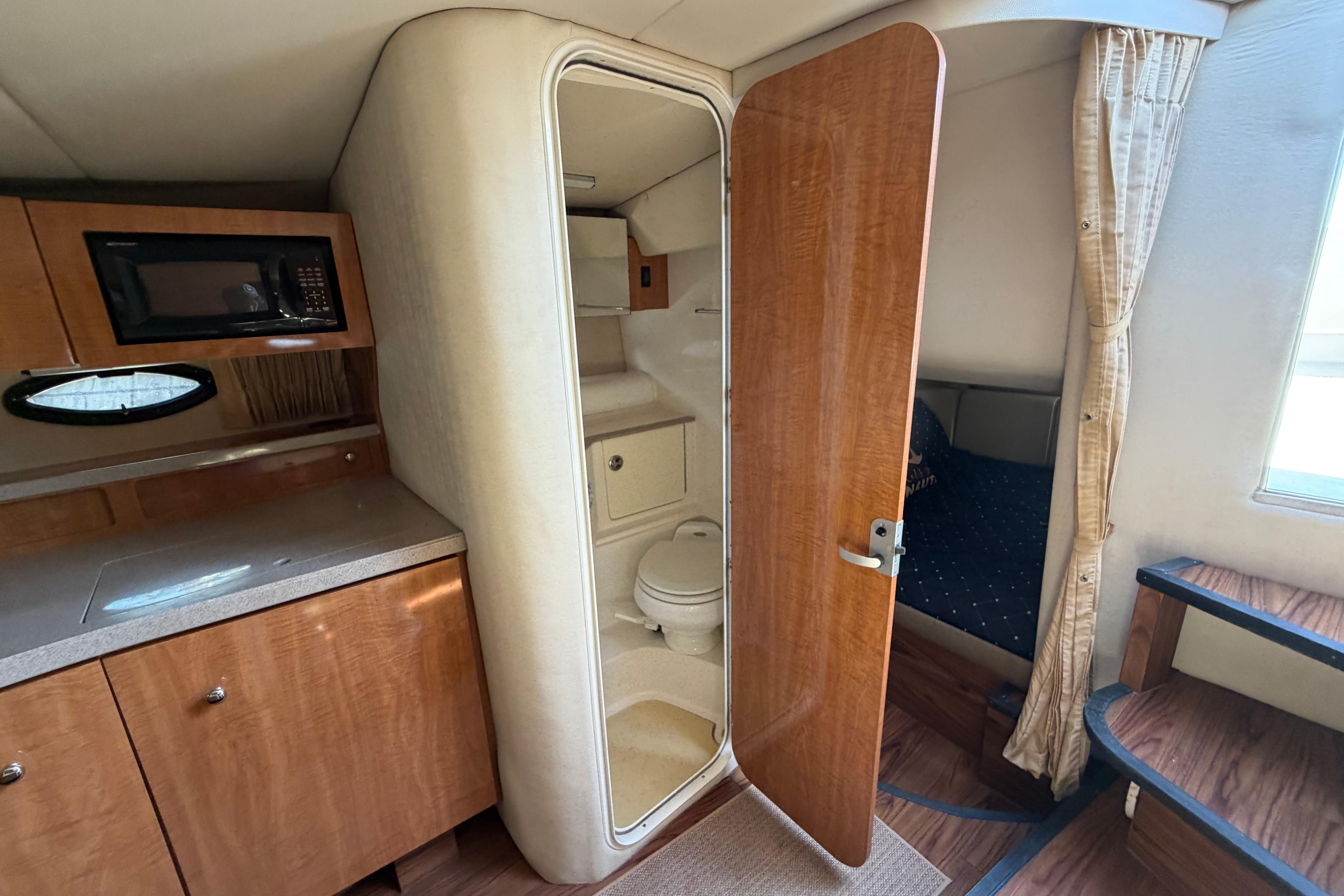 2003 Regal Commodore 3260 interior with kitchenette, bathroom, and cozy sleeping area.