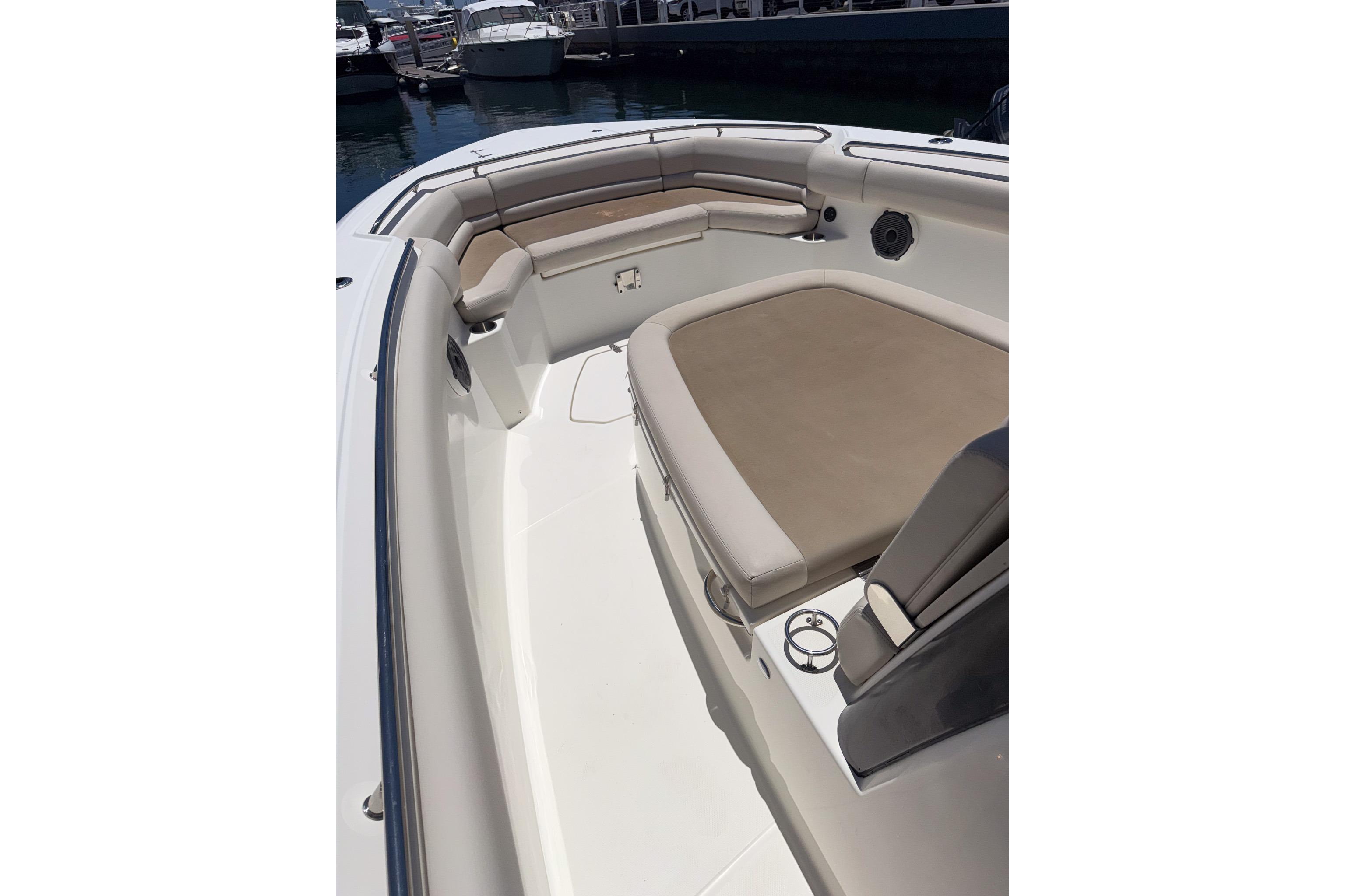 2021 Boston Whaler 330 Outrage boat interior with cushioned seating and cup holders.