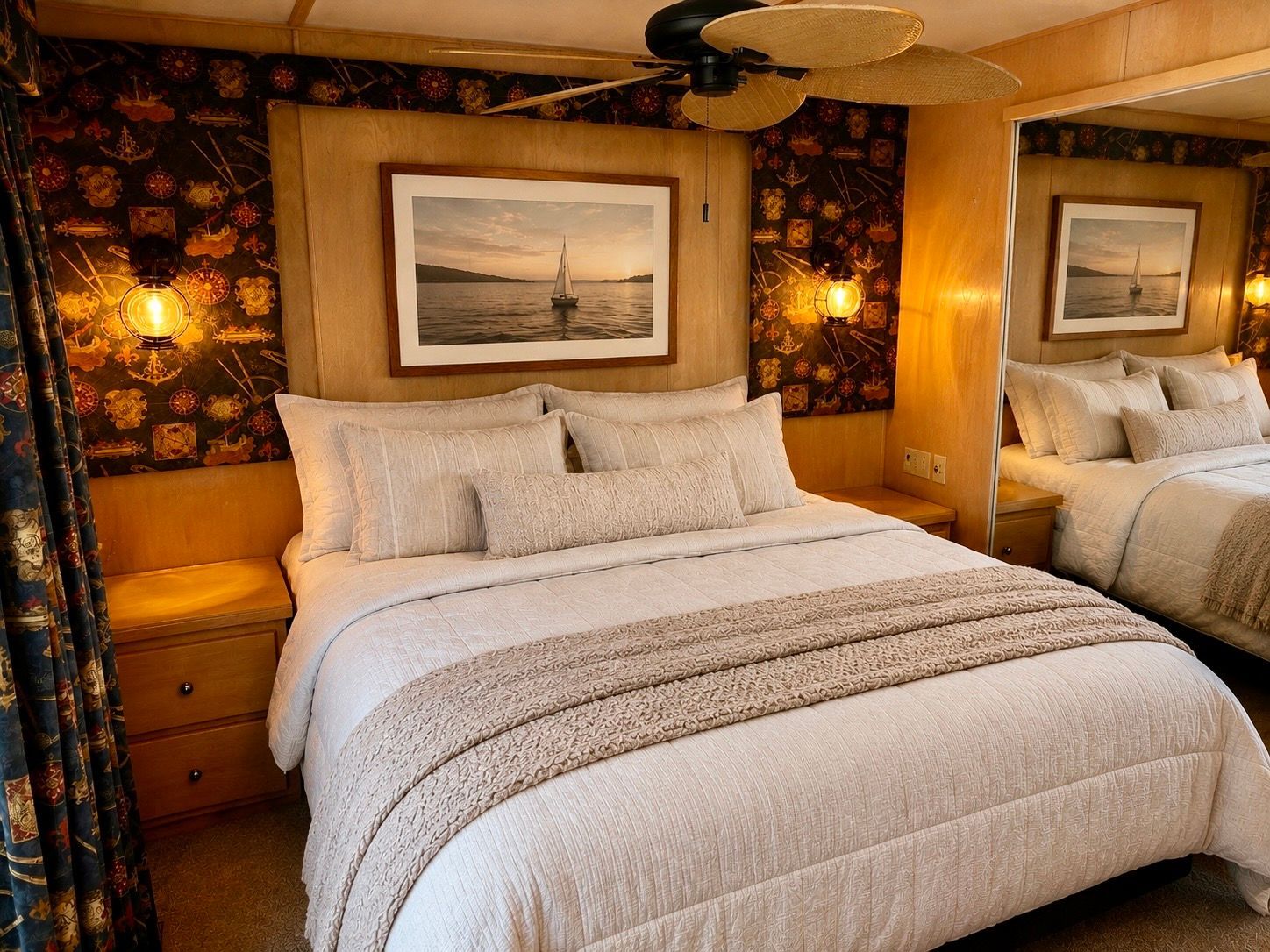 Cozy bedroom with a large bed, wood paneling, and a sailboat picture on the wall.