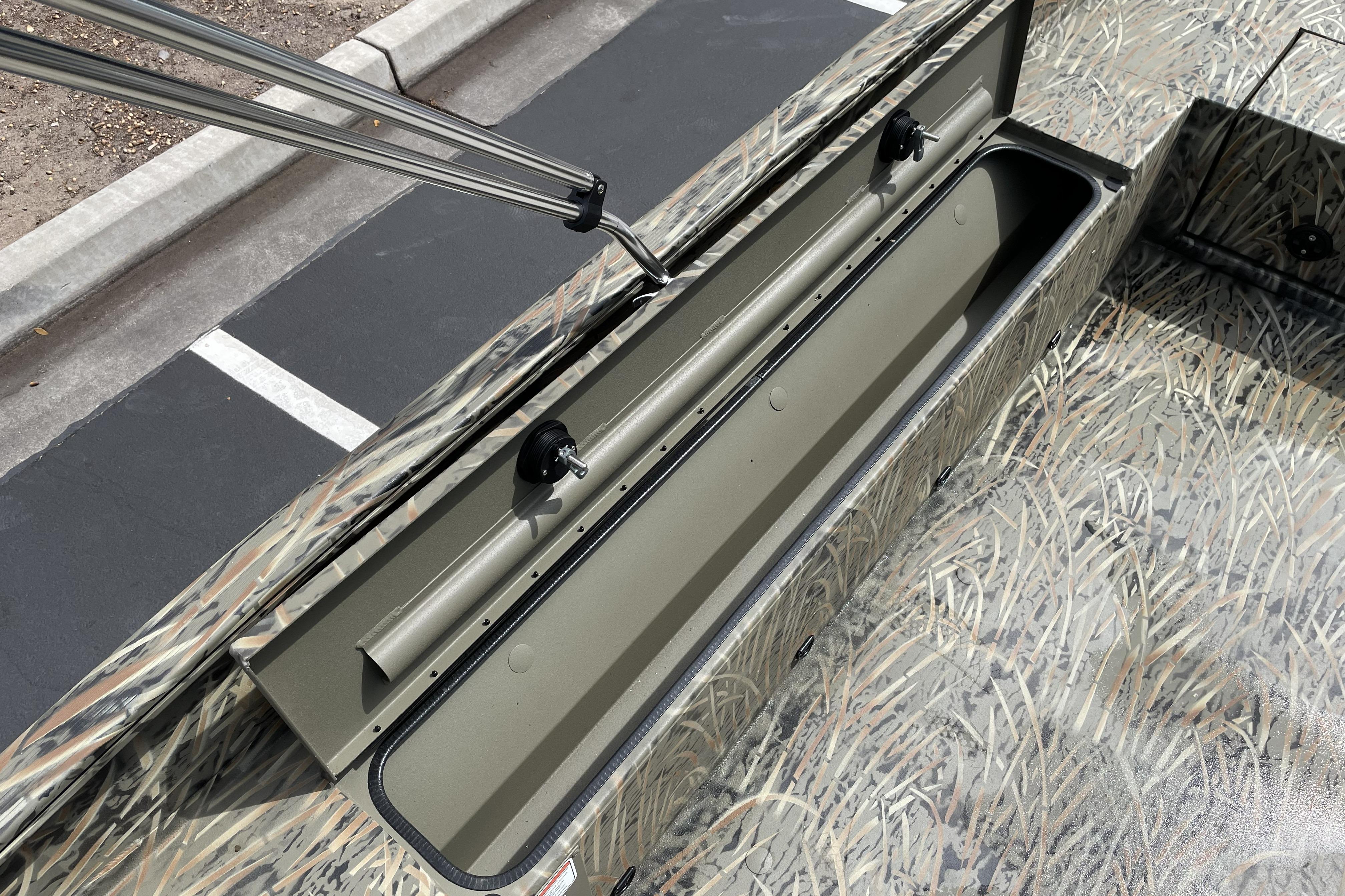 2026 Tracker Grizzly 1756 T Marsh boat with open storage compartment, camo design.