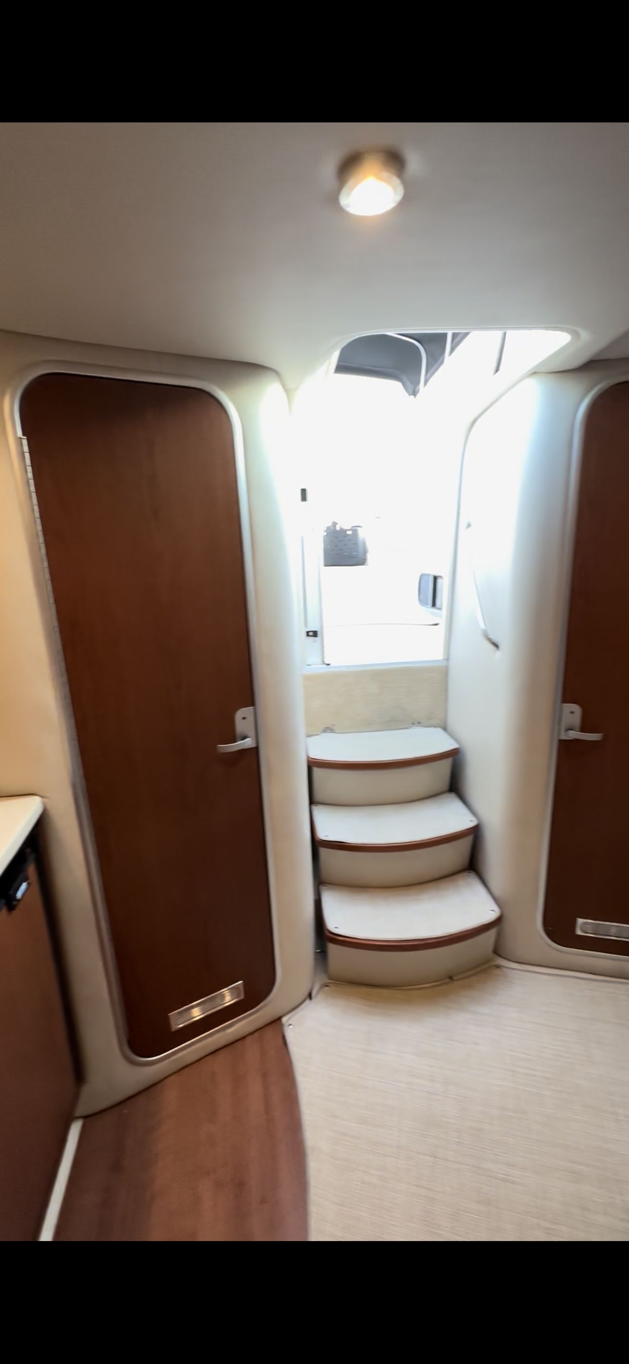 The cabin of a 2004 Chaparral Signature 330 with two wooden doors and a staircase.