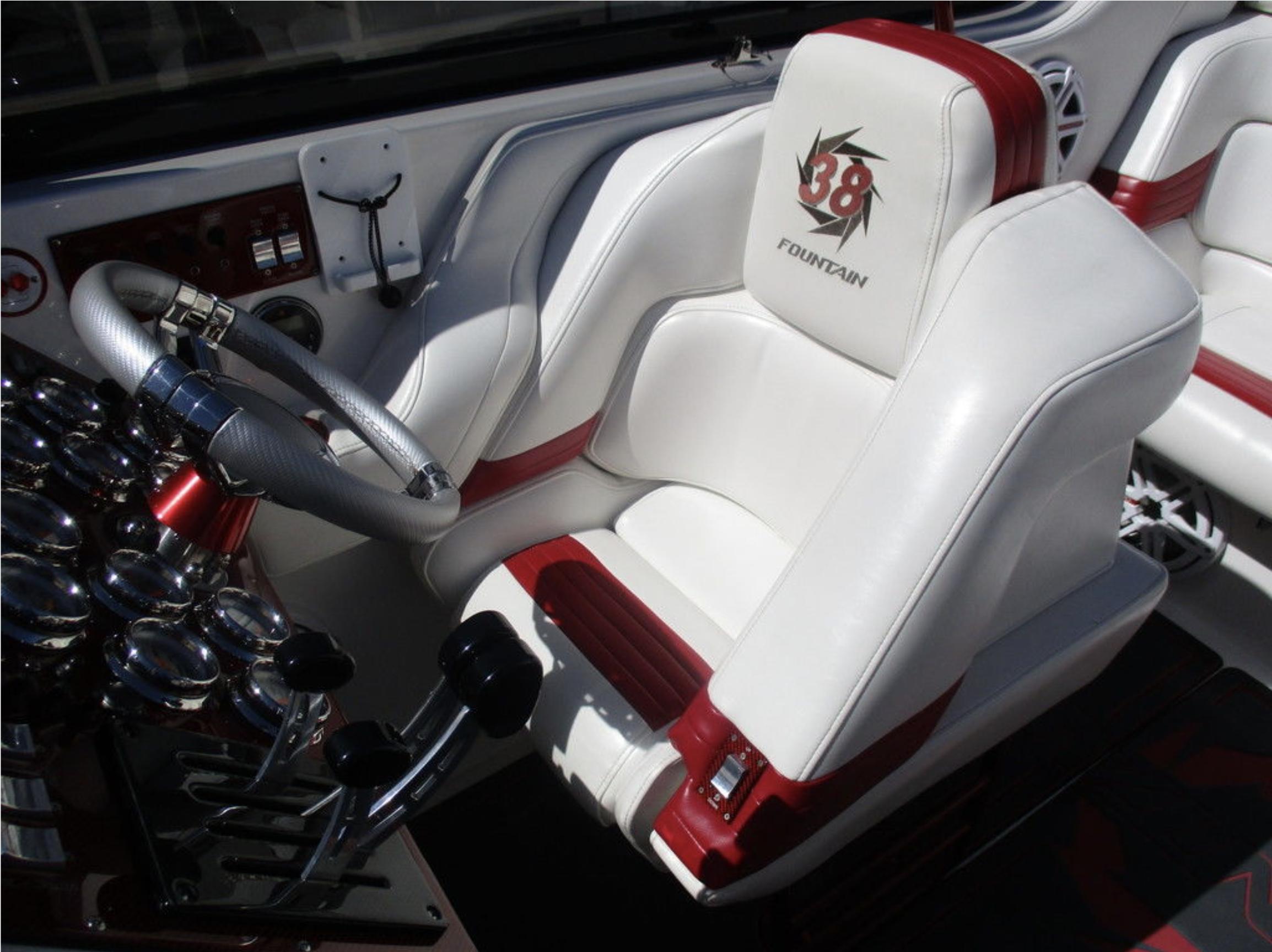 2003 Fountain 38 Lightning boat cockpit with white and red seats and control panel.