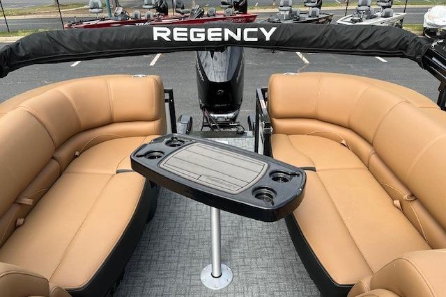 Luxurious 2026 Regency 250 DL pontoon boat interior with tan seating and central table.