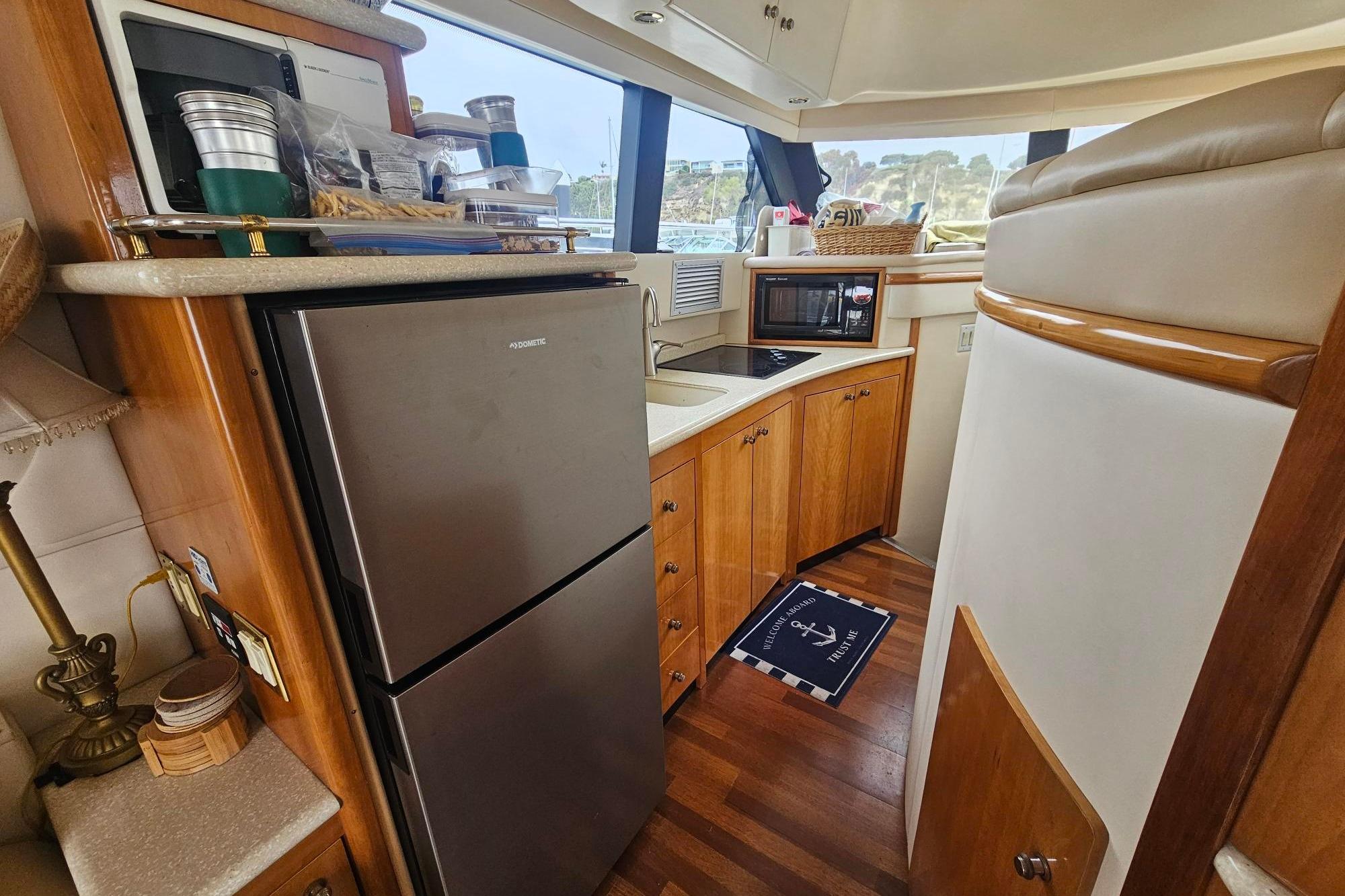 Interior of 2002 Carver 450 Voyager Pilothouse with kitchen amenities and wooden cabinetry.