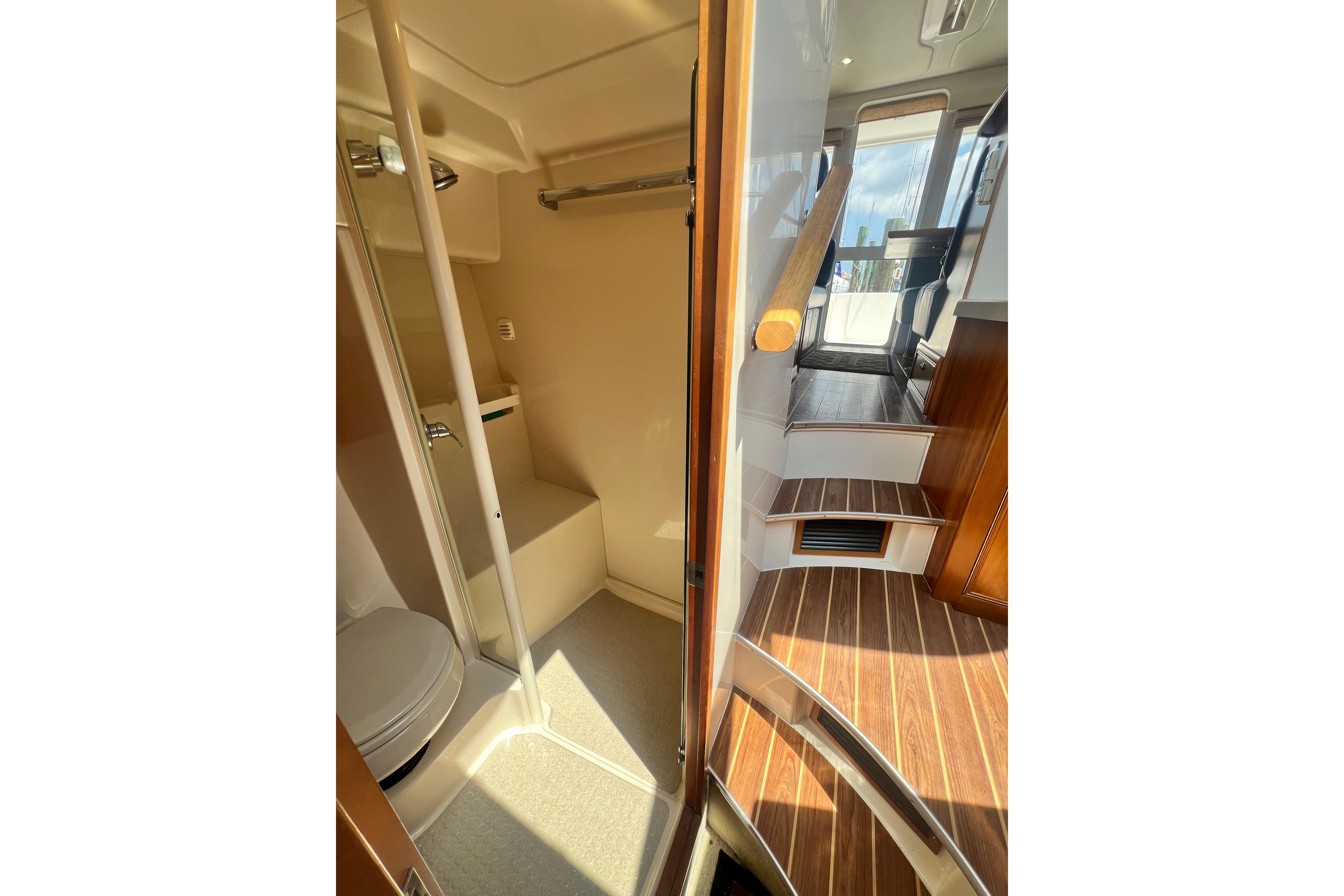 Interior of 2007 Riviera 33 Flybridge yacht, featuring bathroom and wooden stairs.