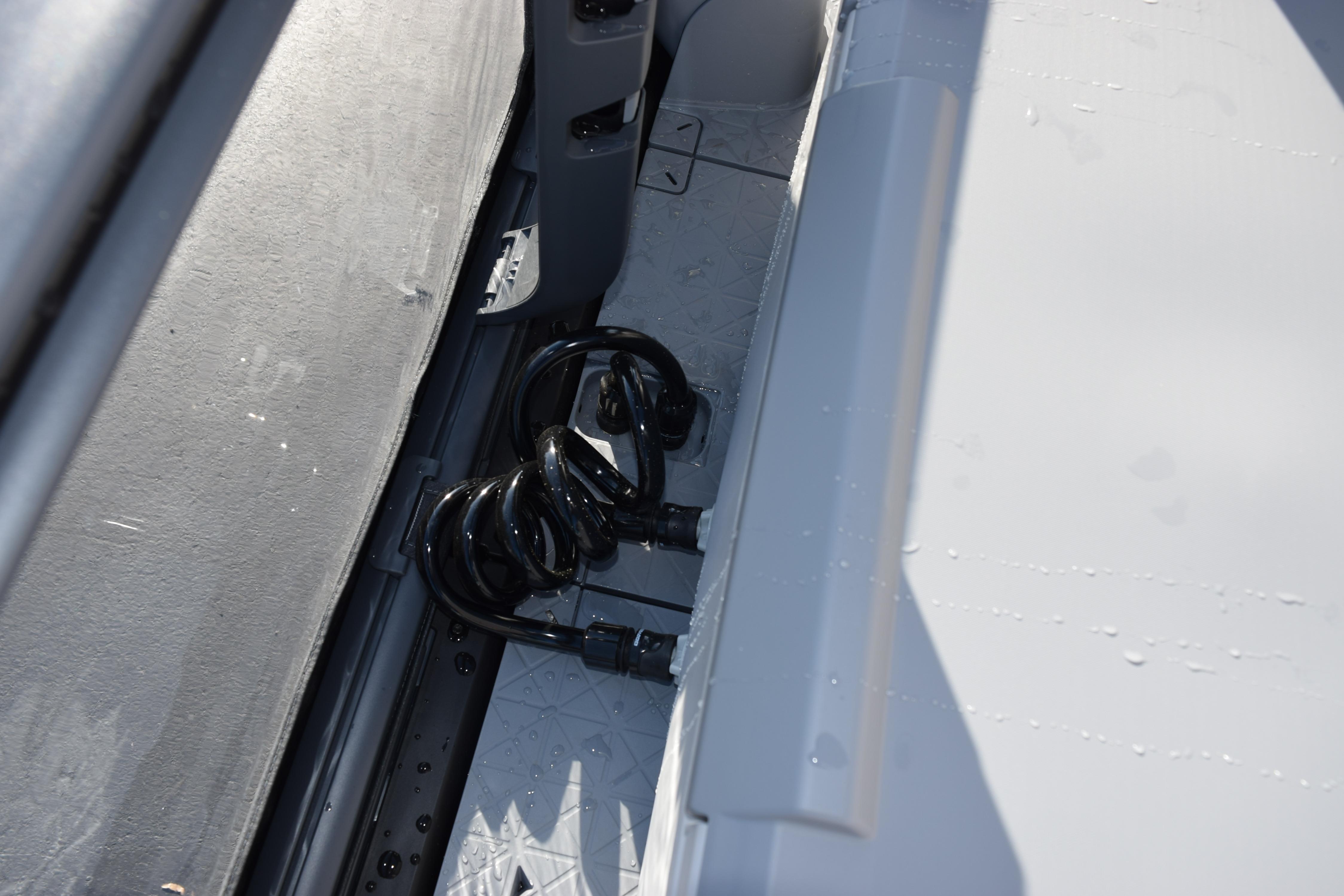 Coiled hose on 2026 Sea-Doo Switch Fish 21 deck, showcasing storage feature.
