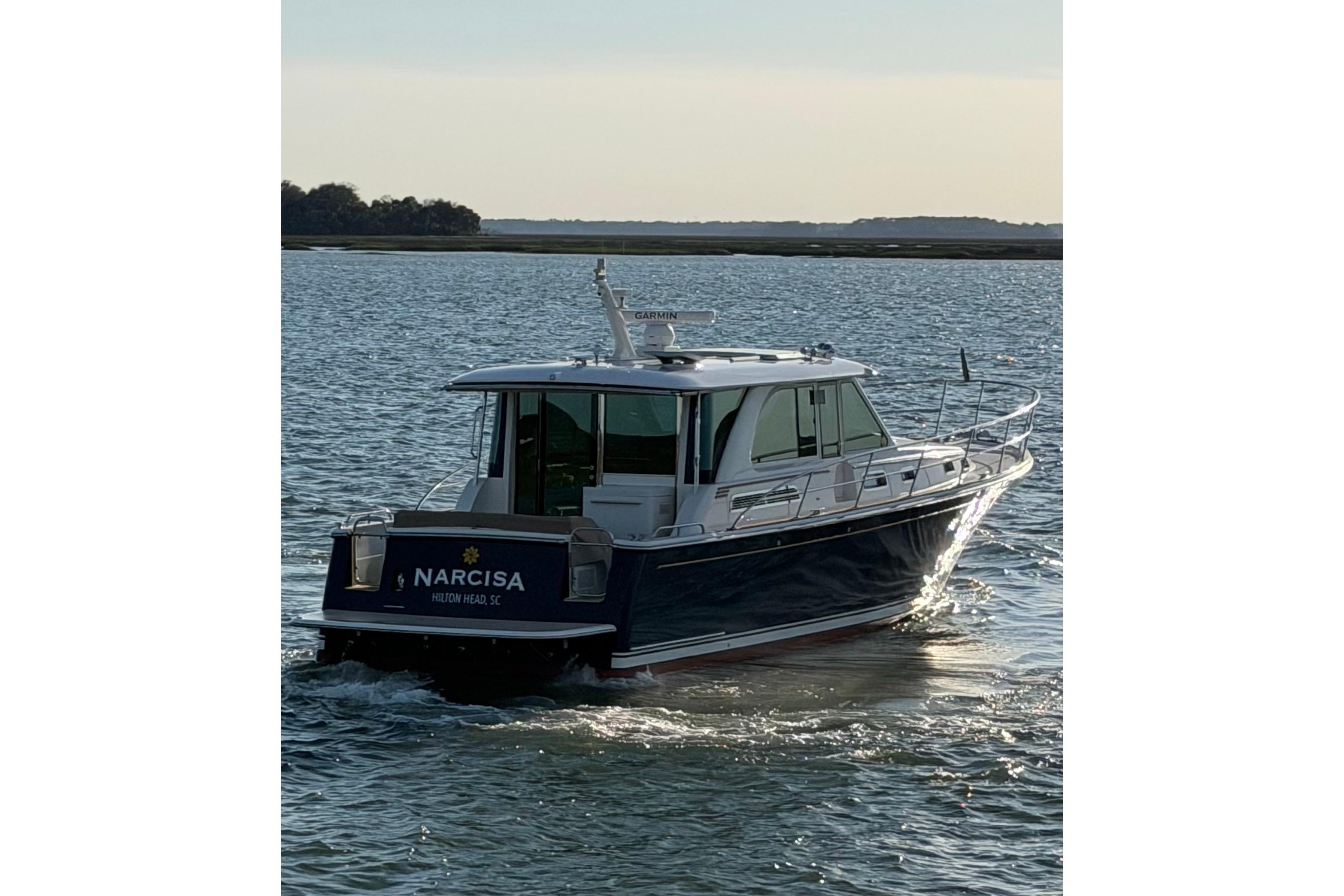 2021 Sabre 45 Salon Express yacht cruising on calm waters at sunset.