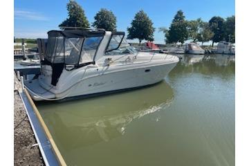 2000 Rinker Fiesta Vee 310 boat docked in a serene marina setting.
