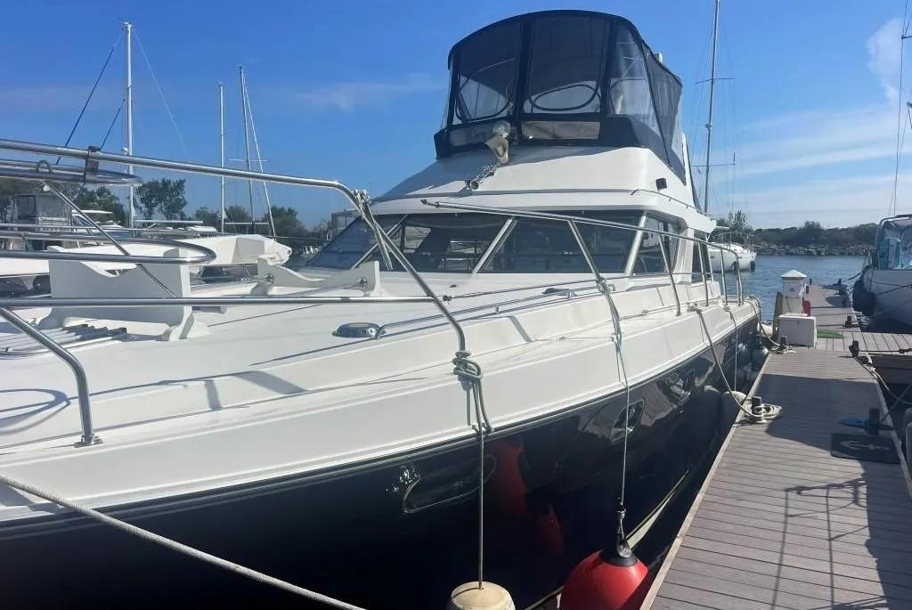 1985 Princess Sedan Flybridge yacht docked at marina under clear blue sky.