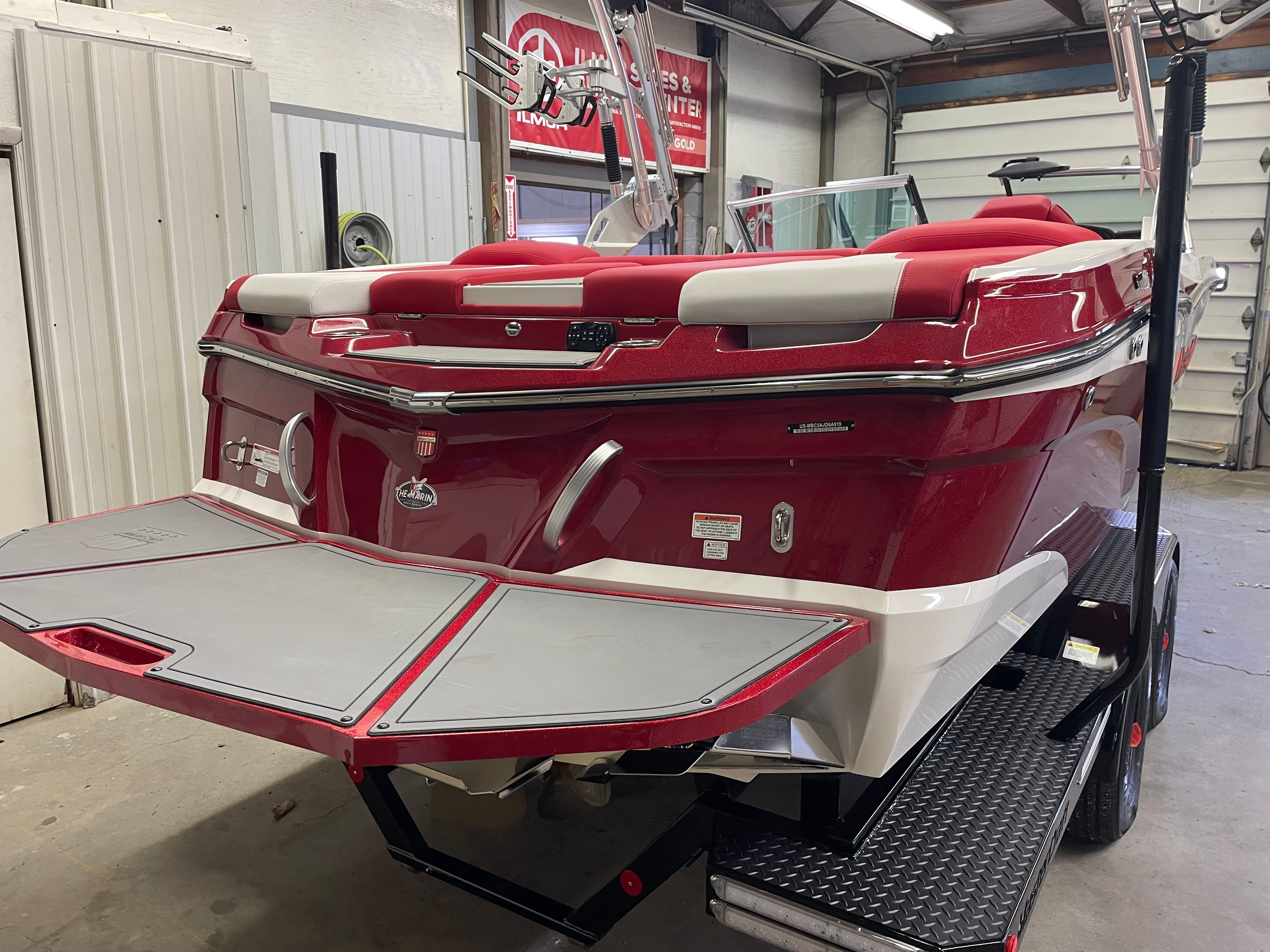 Red 2019 Master XT21 boat indoors on trailer.