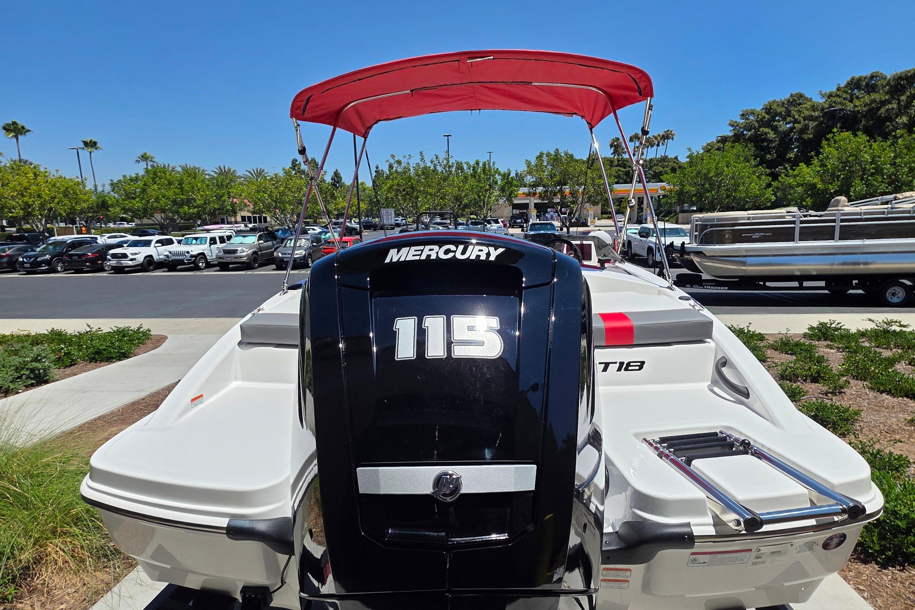 2026 Tahoe T18 boat with Mercury 115 engine, red canopy, parked outdoors.