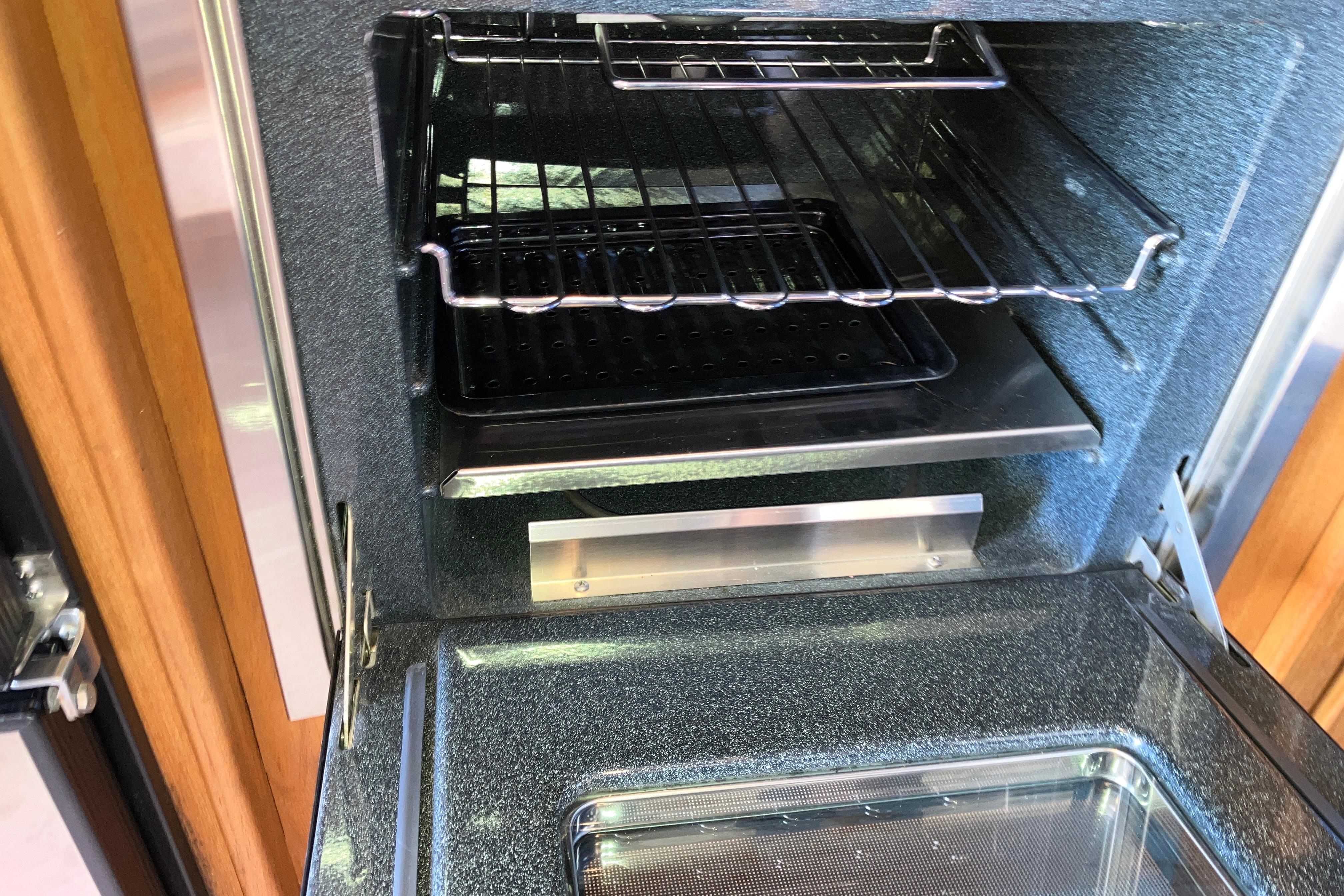 Interior of a 1999 Mainship 350 Trawler oven with racks and tray.