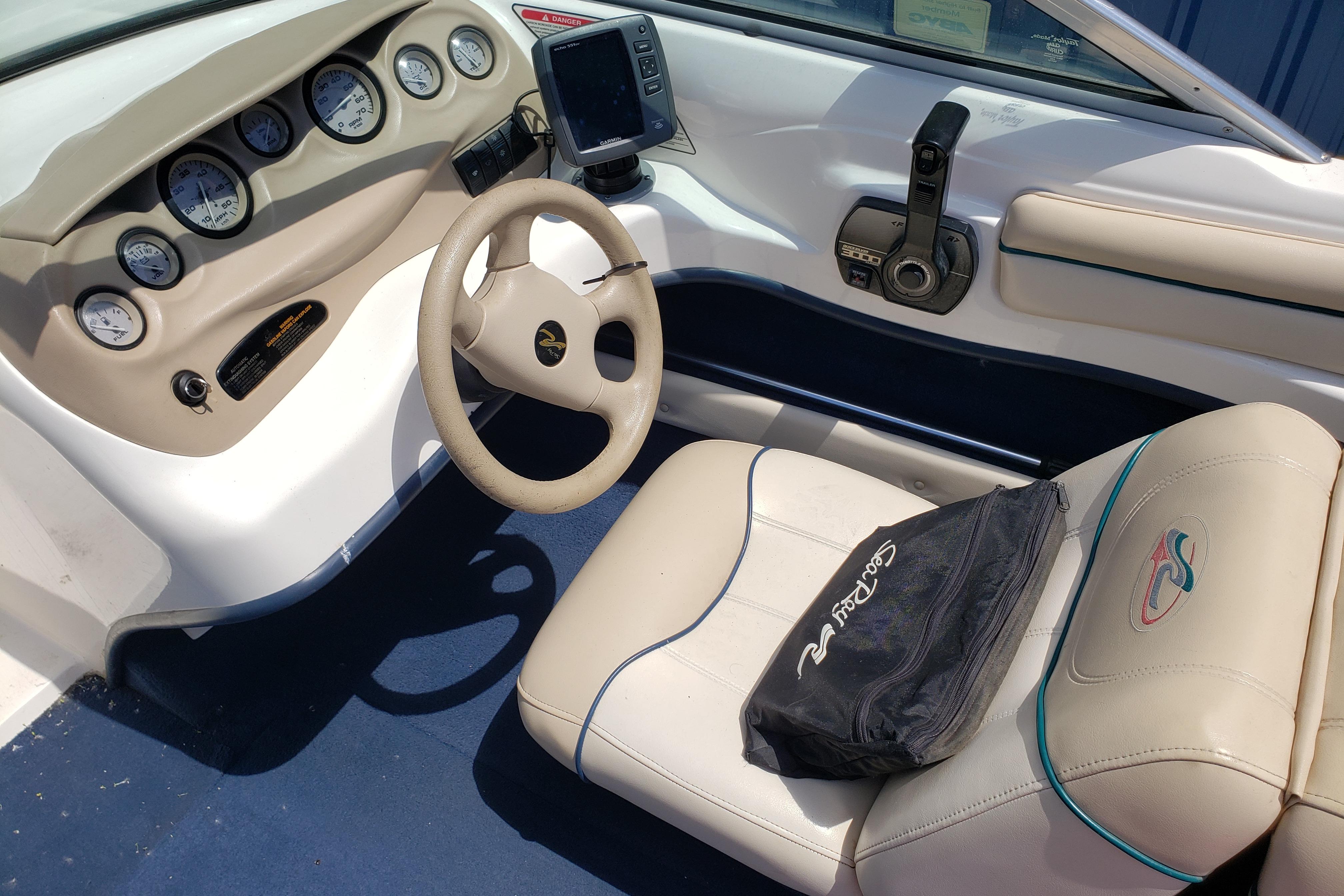 Interior of a 1998 Sea Ray 180 Bow Rider boat with steering wheel and gauges.