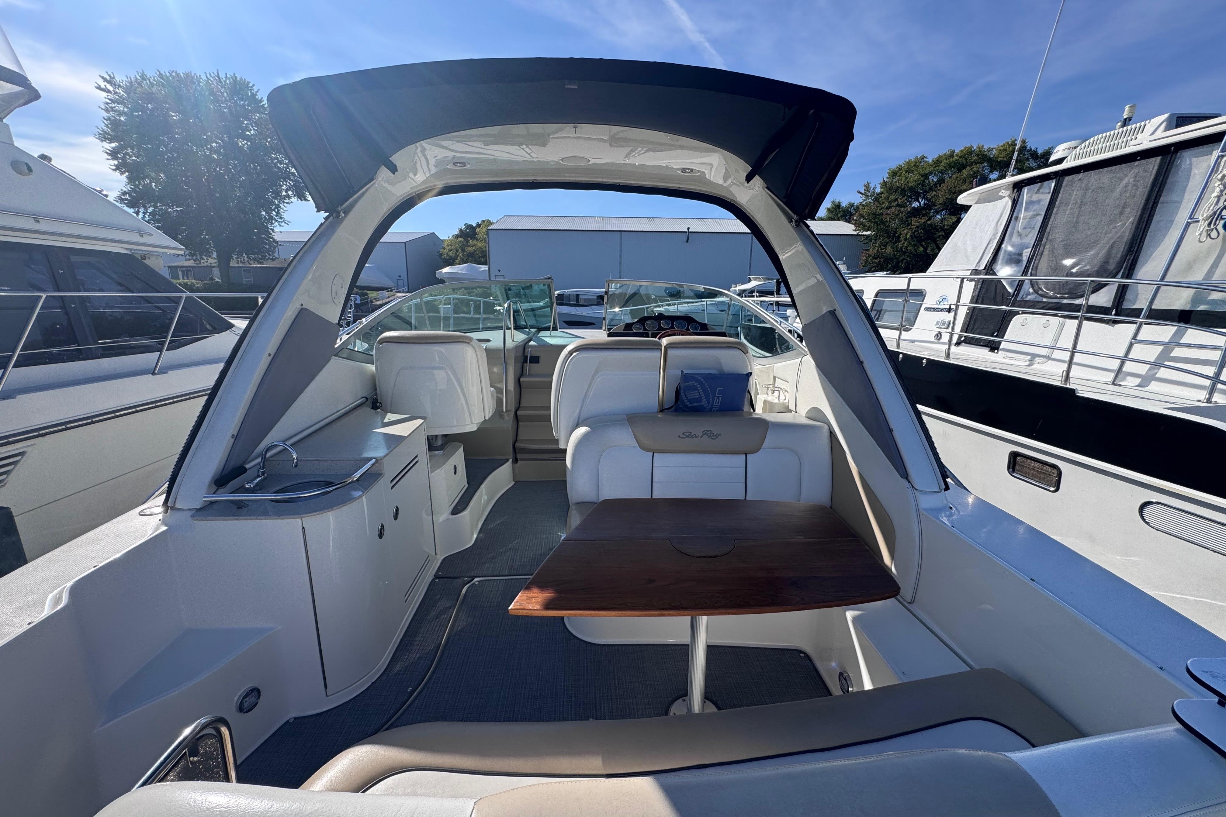 2008 Sea Ray 350 Sundancer interior with seating and table, docked among other boats.