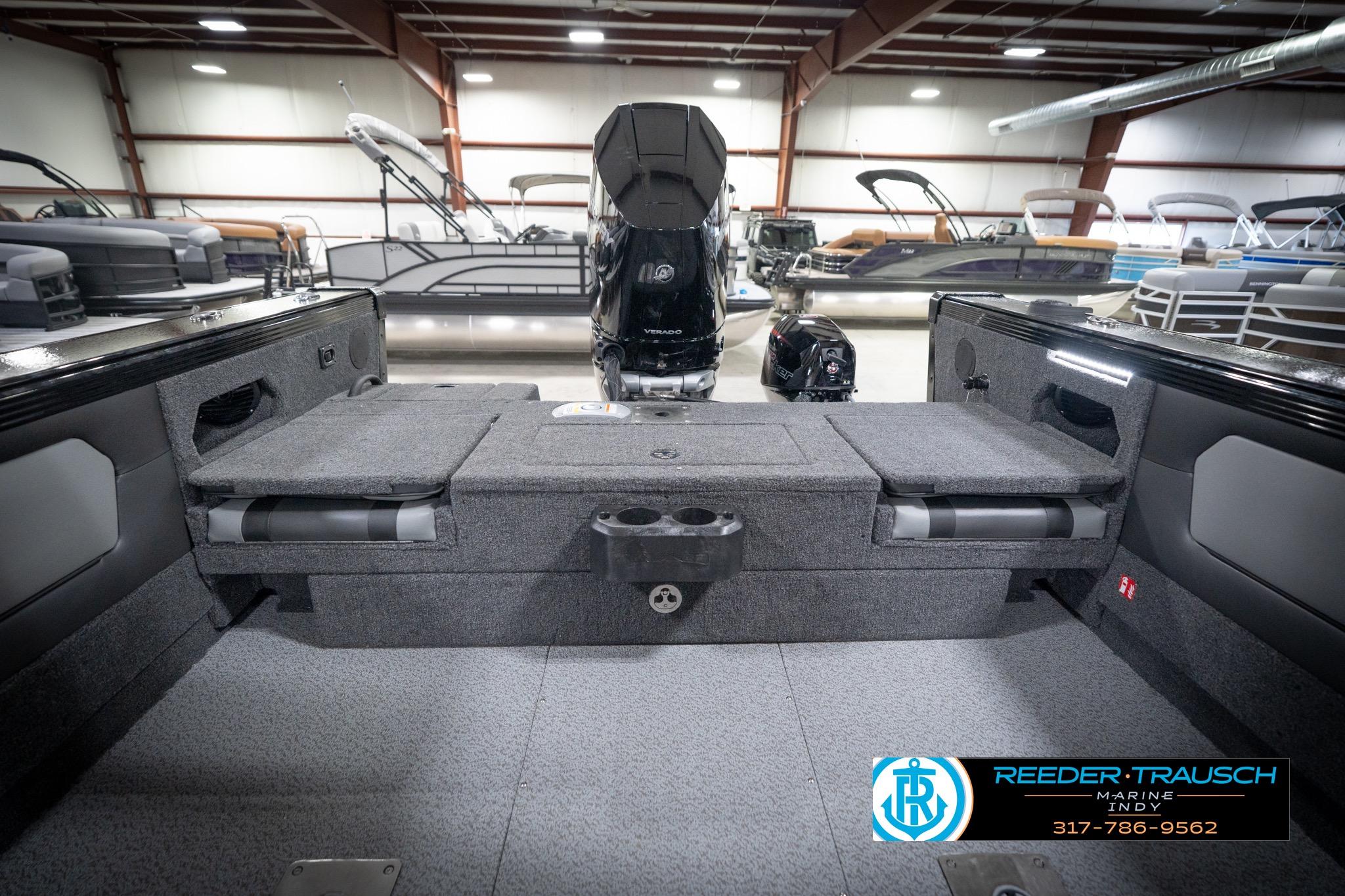 2026 Lund 2275 Baron boat interior with seating and motor in showroom.