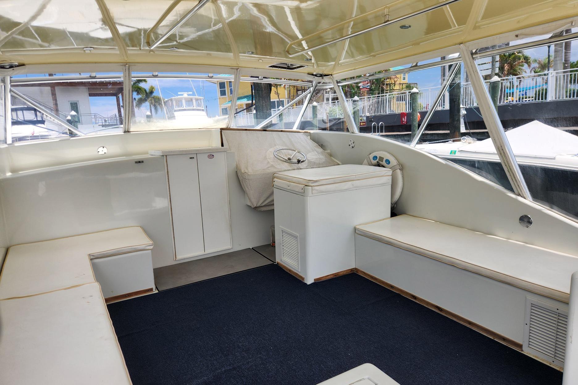 1987 Young Brothers Custom Sport Fish boat interior with seating and helm, docked at marina.