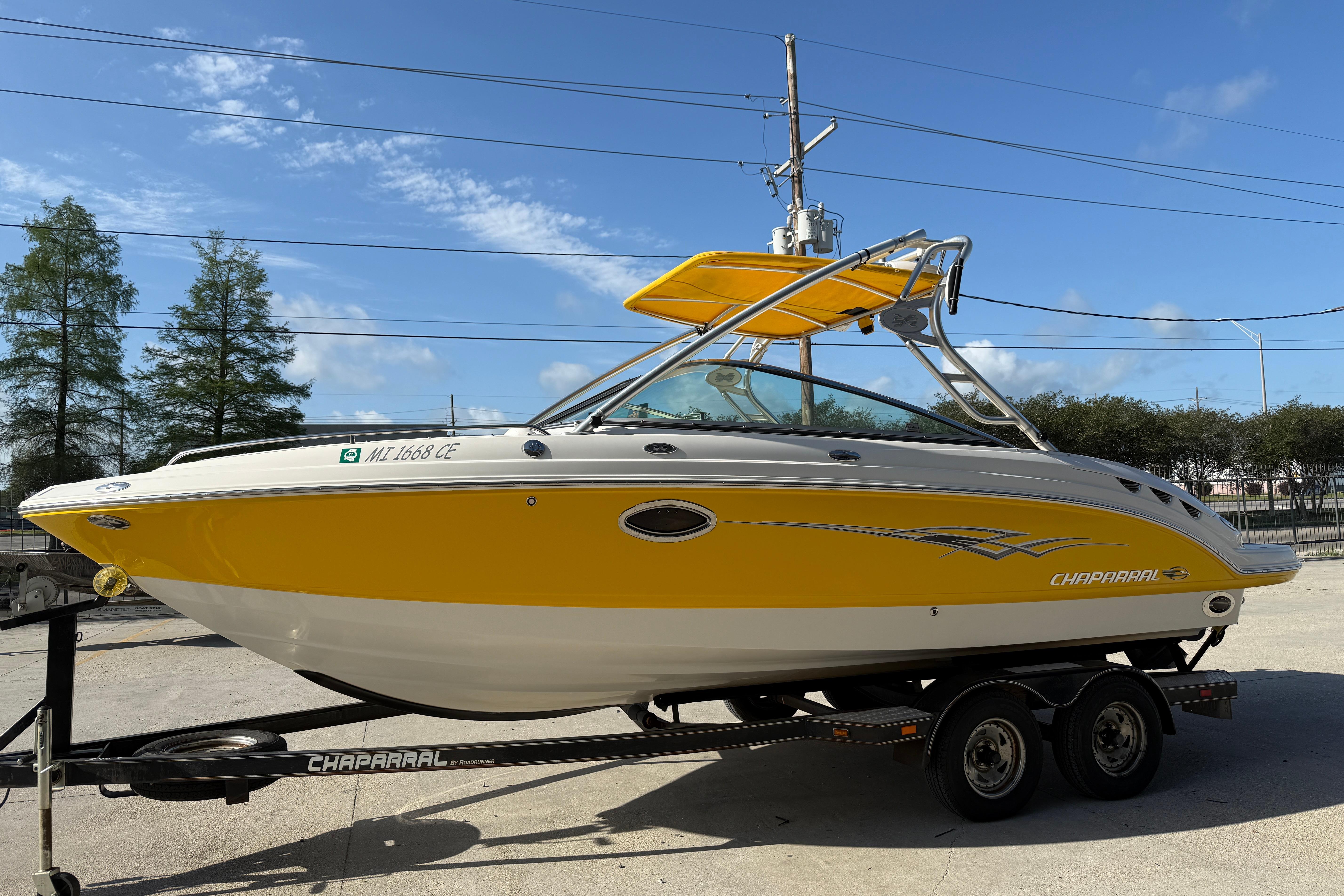 2008 Chaparral 236 SSX boat with yellow and white exterior on trailer.