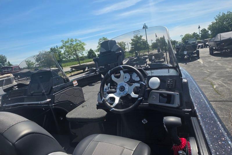 2026 Nitro ZV21 boat interior with steering wheel and dashboard, parked outdoors.
