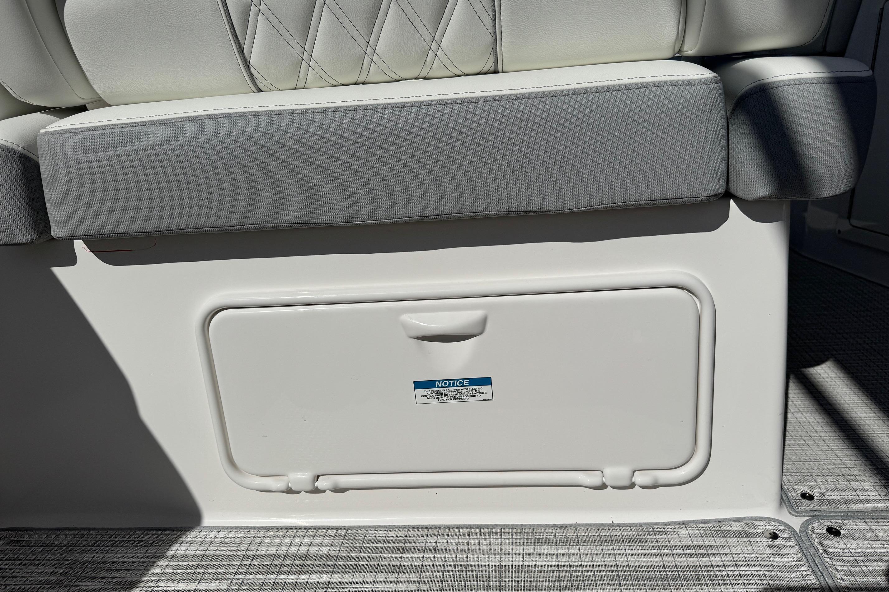 2026 Regal 33 XO boat seat with storage compartment, featuring white and gray upholstery.