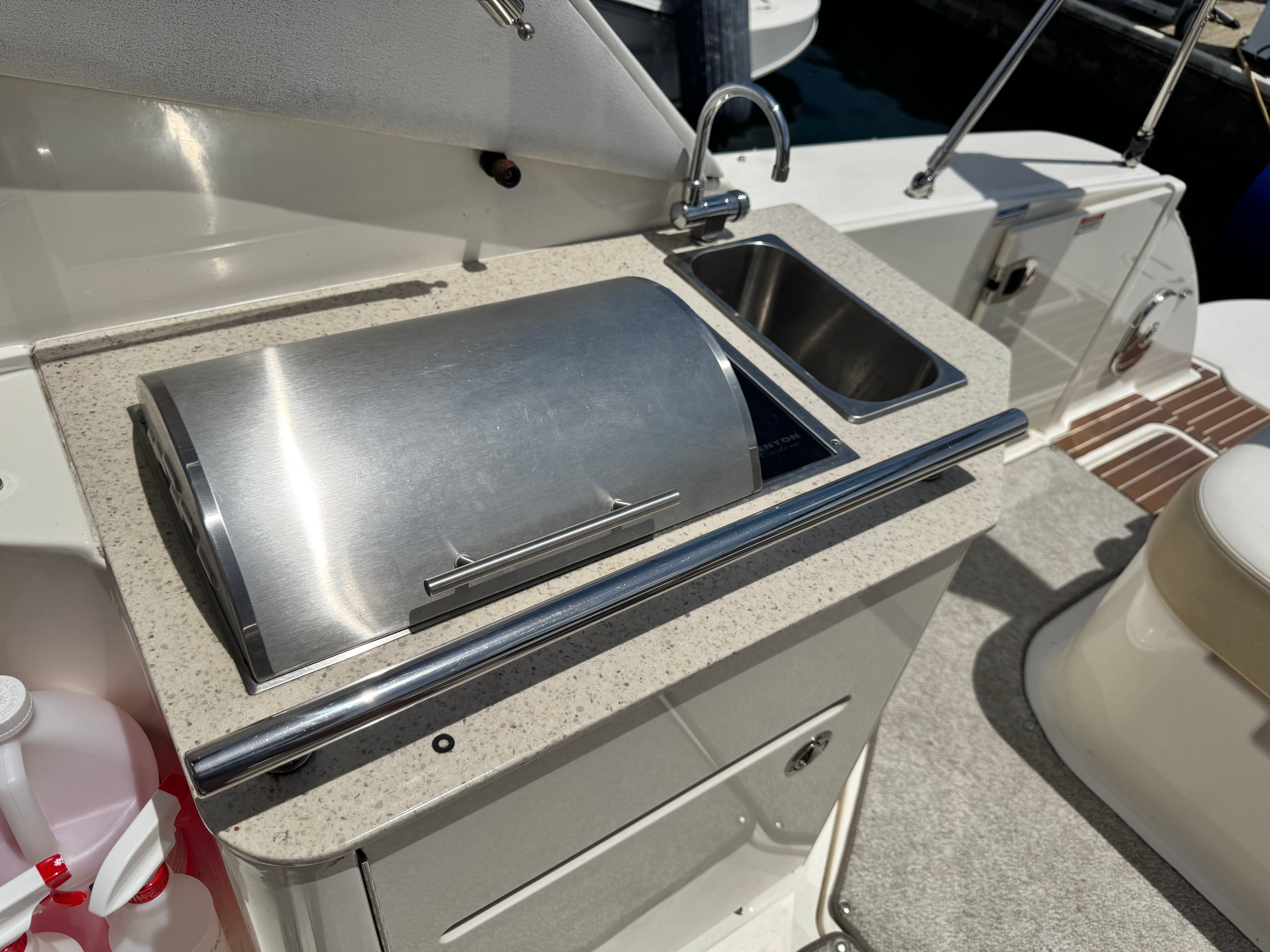 The 2010 Sea Ray Sundancer 310 features an outdoor kitchen with a grill and sink.