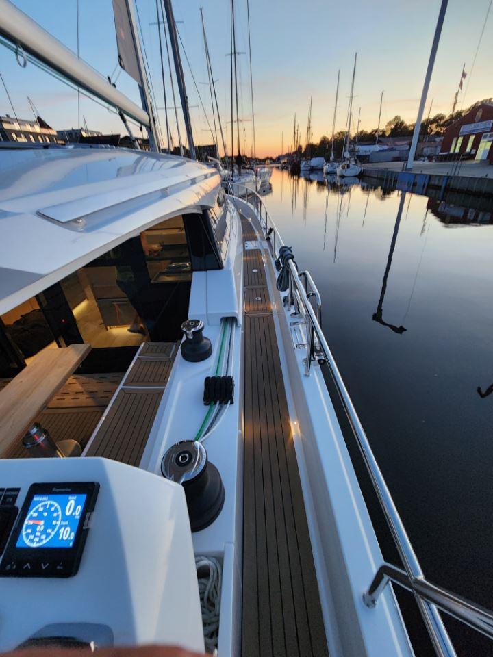 2025 Moody 48 DS yacht docked at sunset, featuring sleek design and modern navigation instruments.