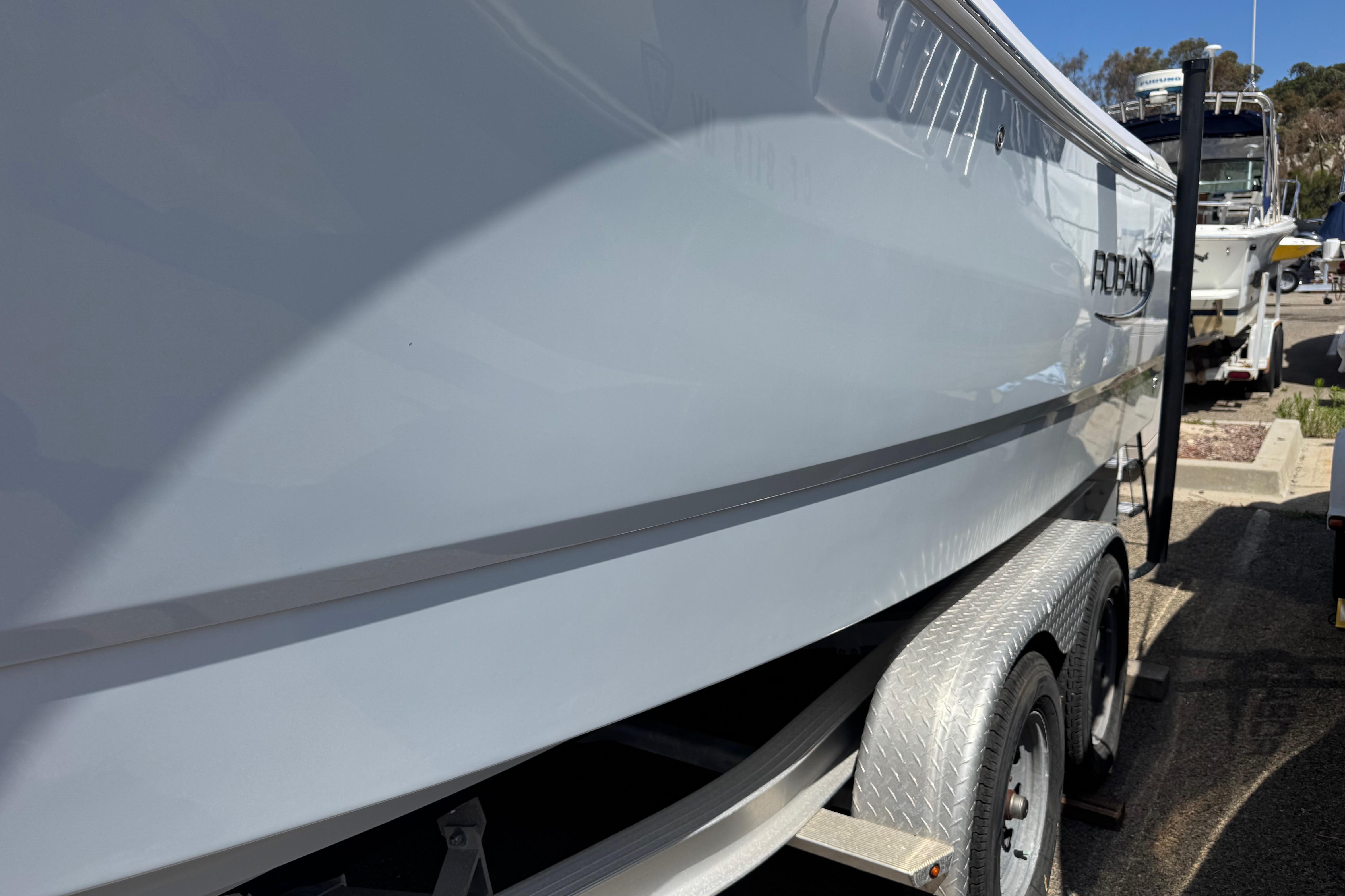 2022 Robalo R230 Center Console boat on trailer, side view in marina setting.